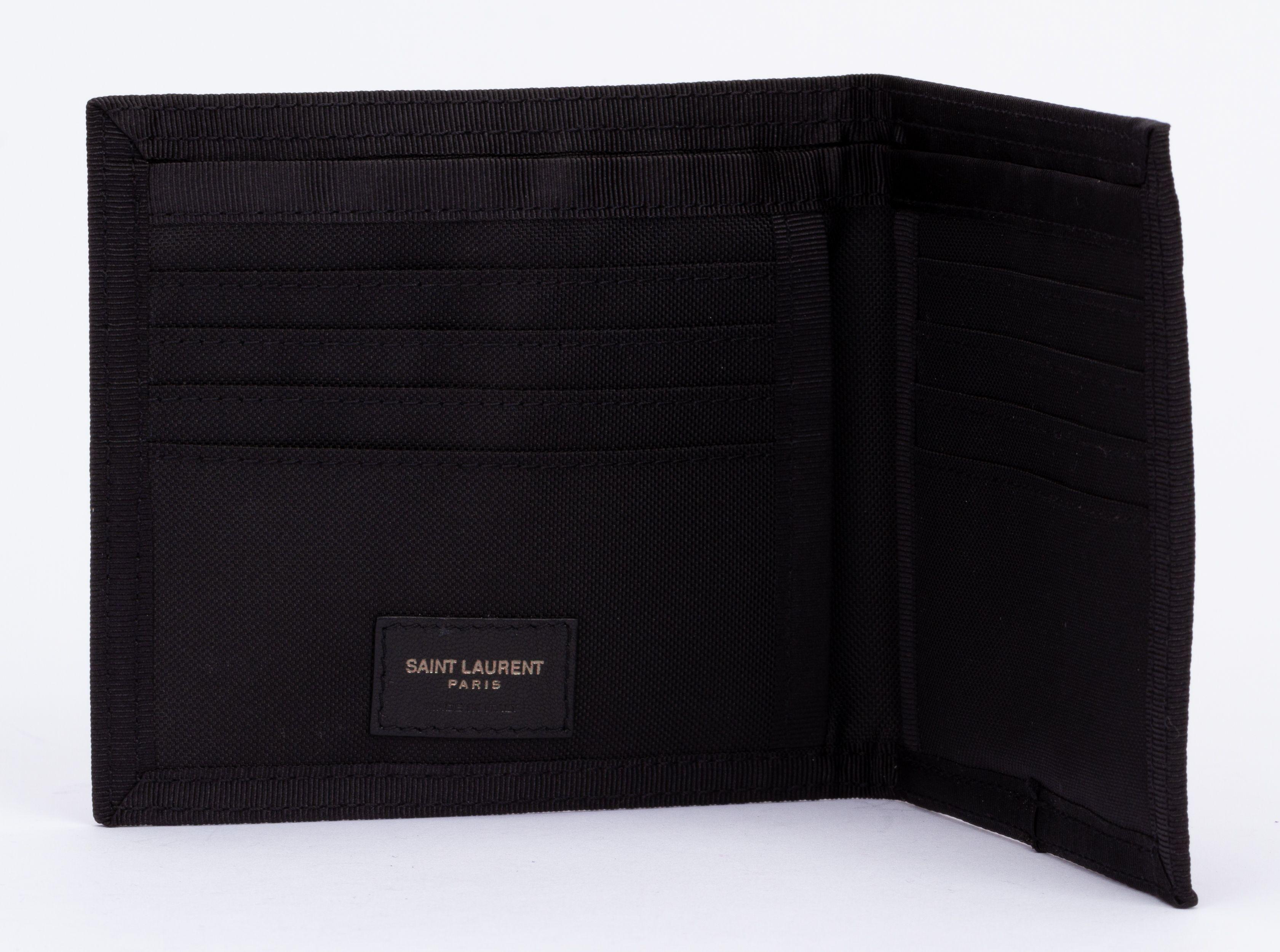 Portafoglio bifold nuovo di zecca di Yves Saint Laurent in tessuto tecnico nero. Include la scatola originale e la copertina antipolvere.
