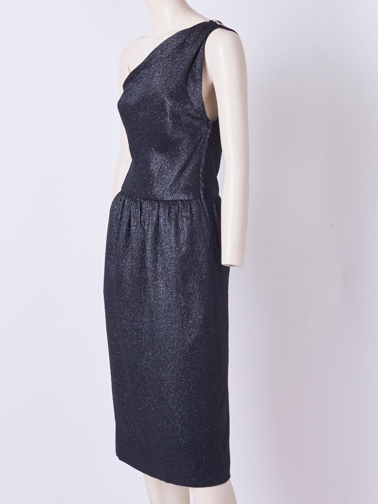 Yves Saint Laurent, Rive Gauche, one shoulder, black matellase, cocktail dress having a subtle, lurex, textured sheen. Dress has a fitted bias cut, bodice, with a slightly dropped gathered, waist, and hidden side pockets.  Diamante buttons at the