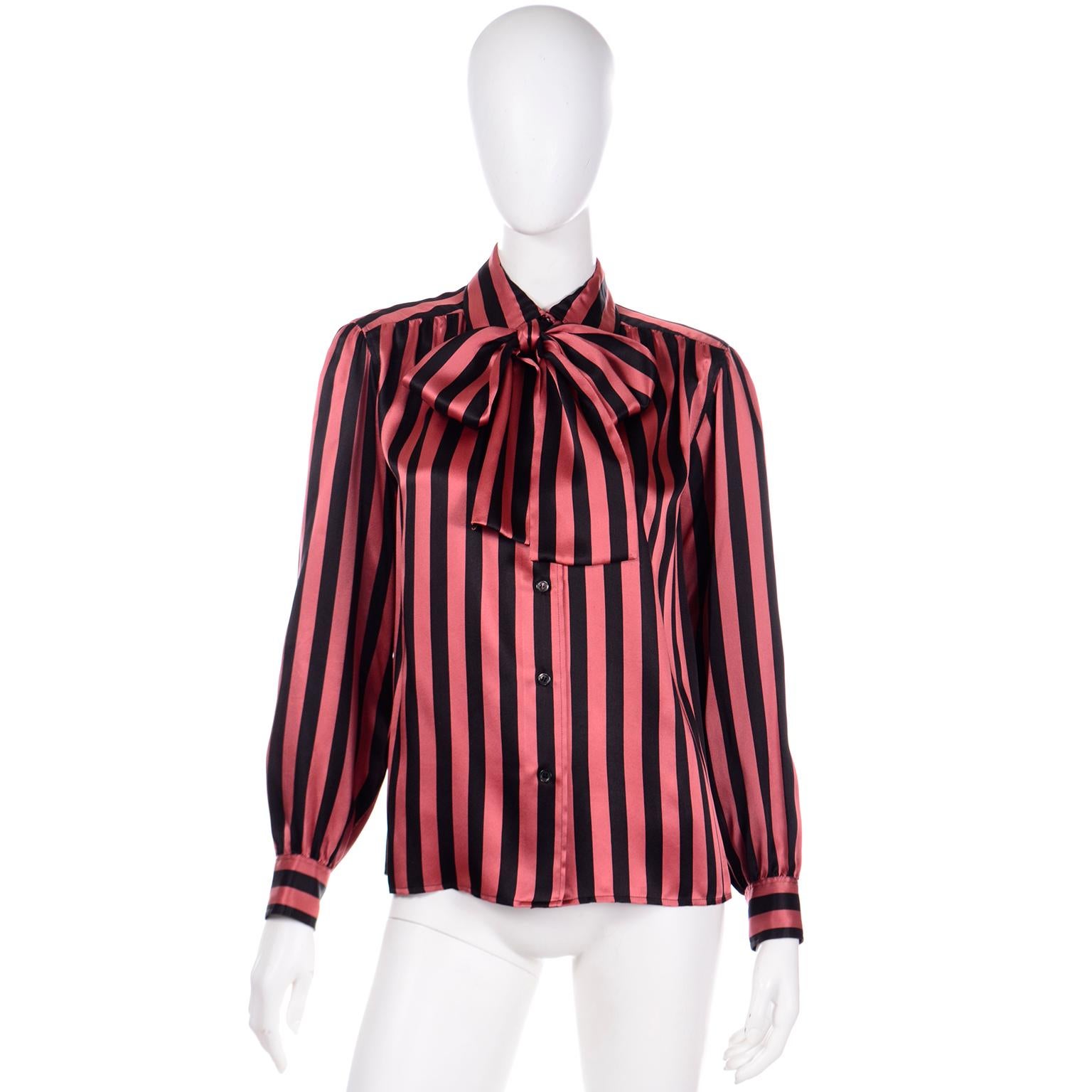 Diese Vintage-Bluse von YSL aus den frühen 1980er Jahren ist aus luxuriöser Seide mit orange-schwarzem Streifendruck. Yves Saint Laurent war ein produktiver Designer, der bei seinen Stücken auch auf das kleinste Detail achtete. Seine Vintage-Blusen