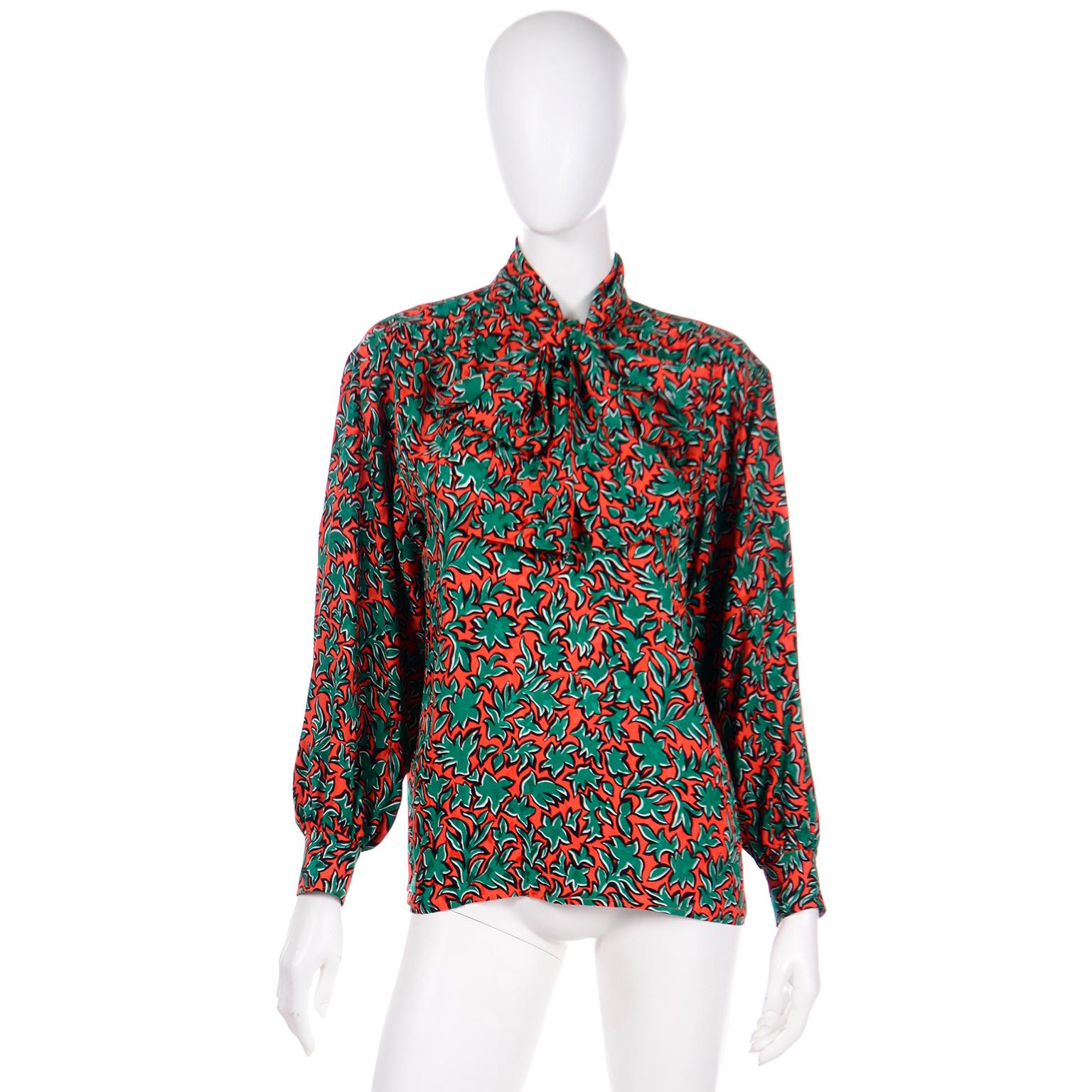 This is a vintage Yves Saint Laurent silk blouse in a bold botanical leaf print in shades of orange and green. This great YSL top has a neck sash that can be tied in a variety of ways, bearing the same orange and green pop art leaf print. The long