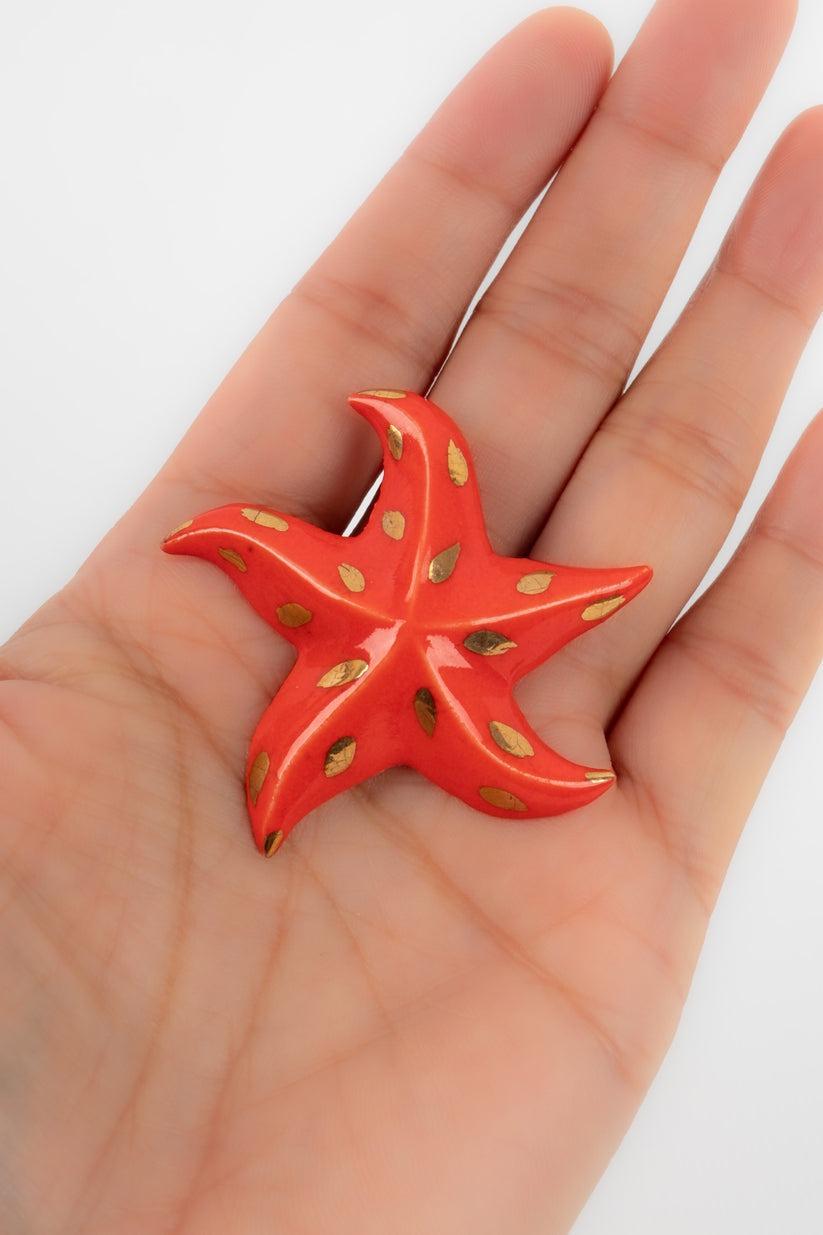 Yves Saint Laurent - (Made in France) Orangey-red resin brooch representing a sea star.

Additional information:
Condition: Very good condition
Dimensions: 4.5 cm x 4.5 cm

Seller Reference: BR42