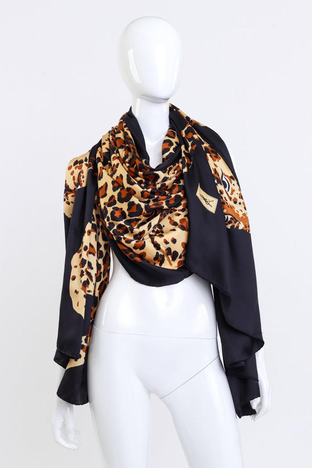 YVES SAINT LAURENT OVERSIZED PROWL OF LEOPARDS SHAWL

This oversized shawl by Yves Saint Laurent showcases a striking design featuring a prowl of leopards against a bold black background. The luxurious fabric has a smooth sateen finish, while the