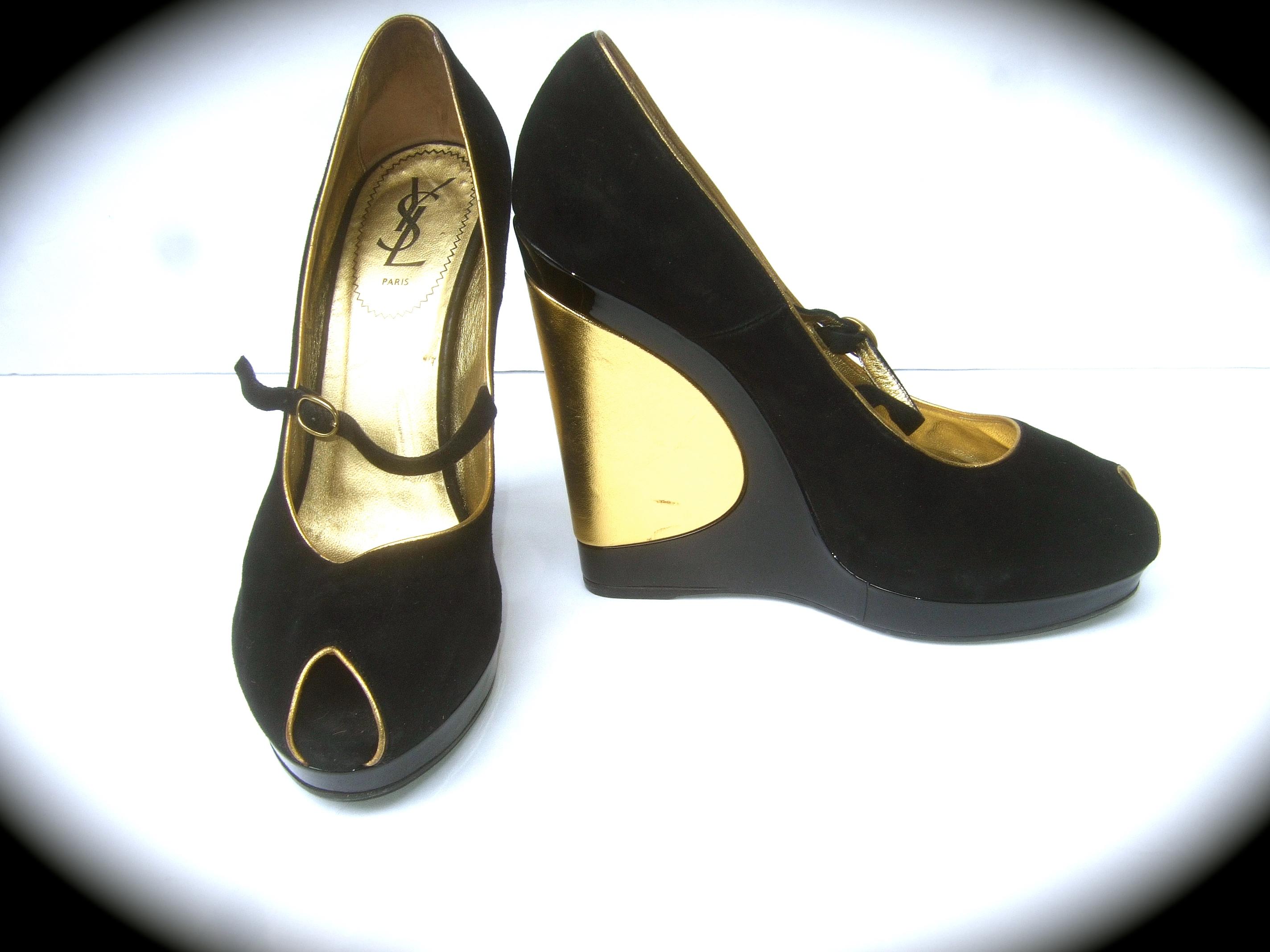 Yves Saint Laurent Paris Black suede & gold leather peep toe Italian wedge platform shoes Size 40 c 21st C

The stylish Italian peep-toe platform wedges are covered with plush black doeskin suede. The sides are designed with shiny black patent