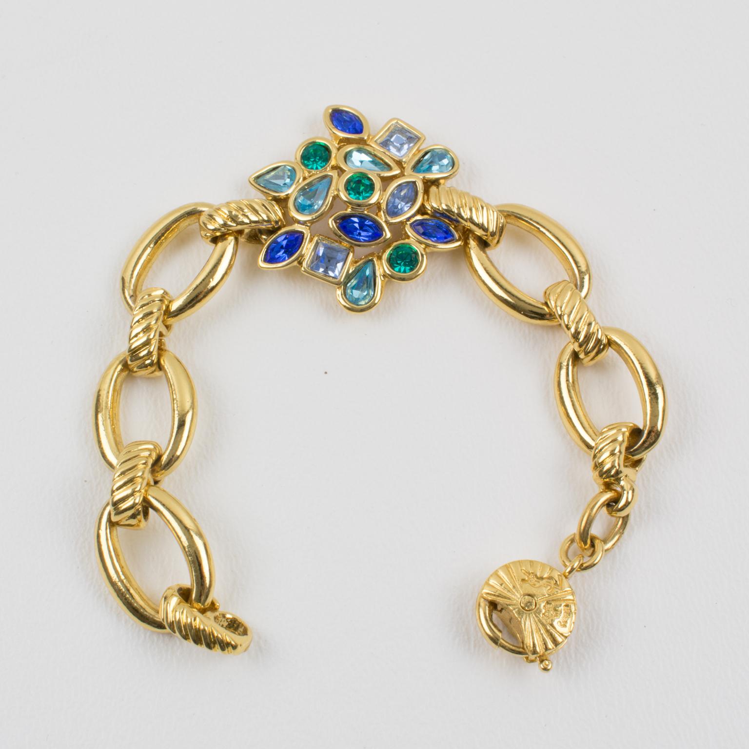 This charming Yves Saint Laurent YSL Paris jeweled gilded metal link bracelet features a gilt worked chain with metal all pierced and textured ornate with one central floral element topped with crystal rhinestones in assorted shapes and colors.