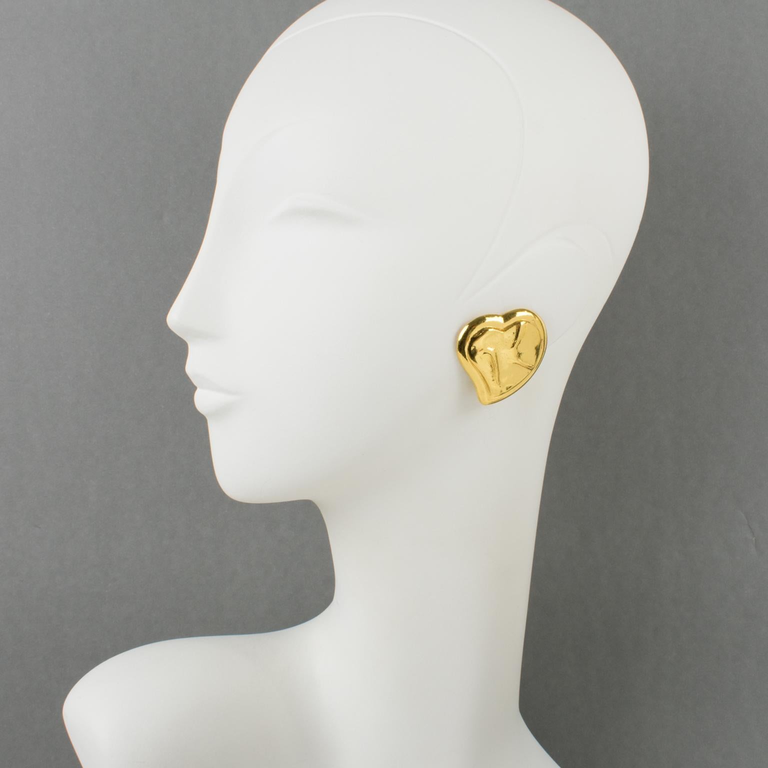These lovely Yves Saint Laurent Paris clip-on stud earrings feature a romantic dimensional heart shape with carving in shiny gilt metal. They are signed at the back with the YSL pierced logo on the clip and the Made in France mark engraved on the