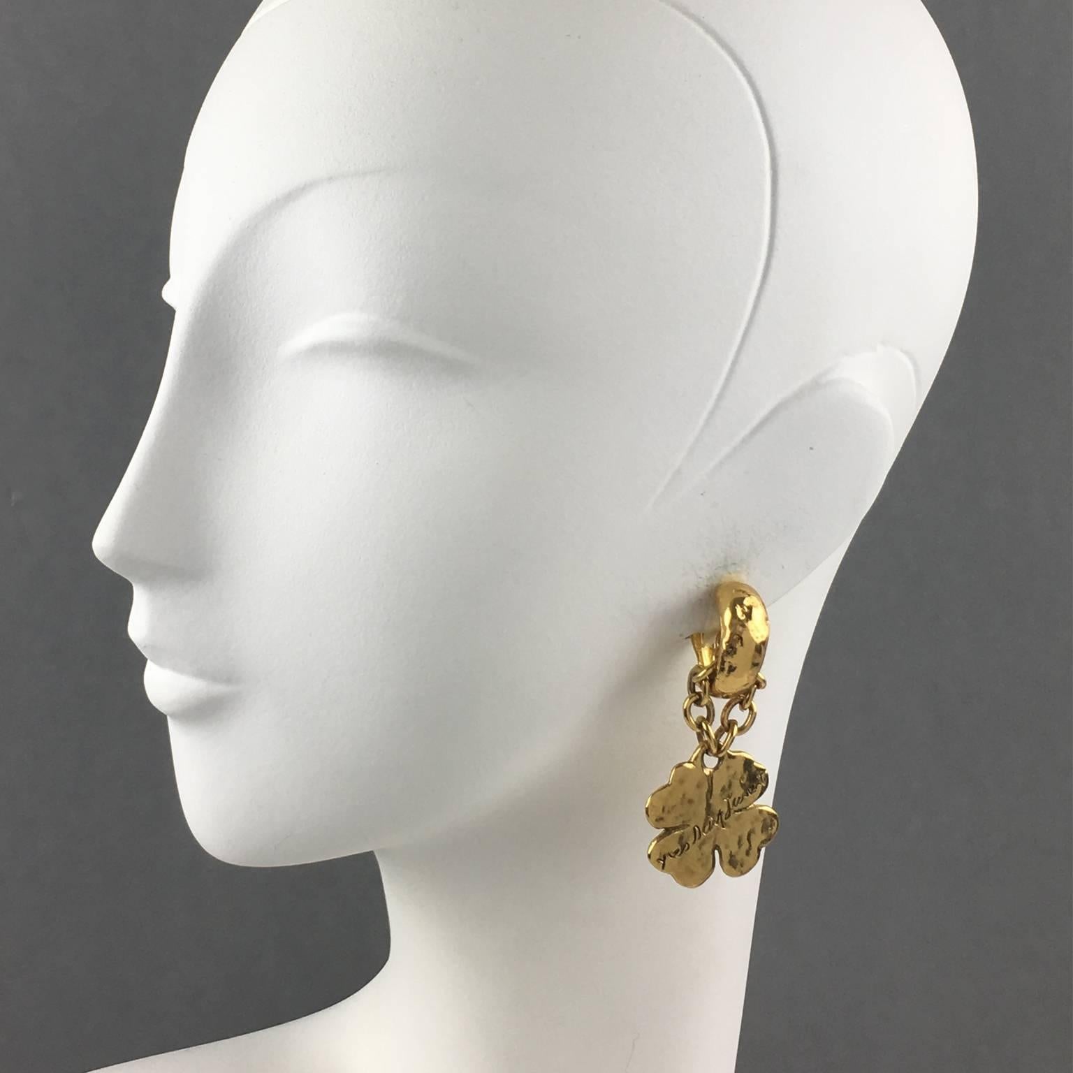 Fabulous Yves Saint Laurent Paris signed clip on earrings. Gilt metal with hand-made feel textured pattern compliment with dangling charm medallion featuring a huge four clover topped with engraved Yves Saint Laurent signature. YSL signature logo