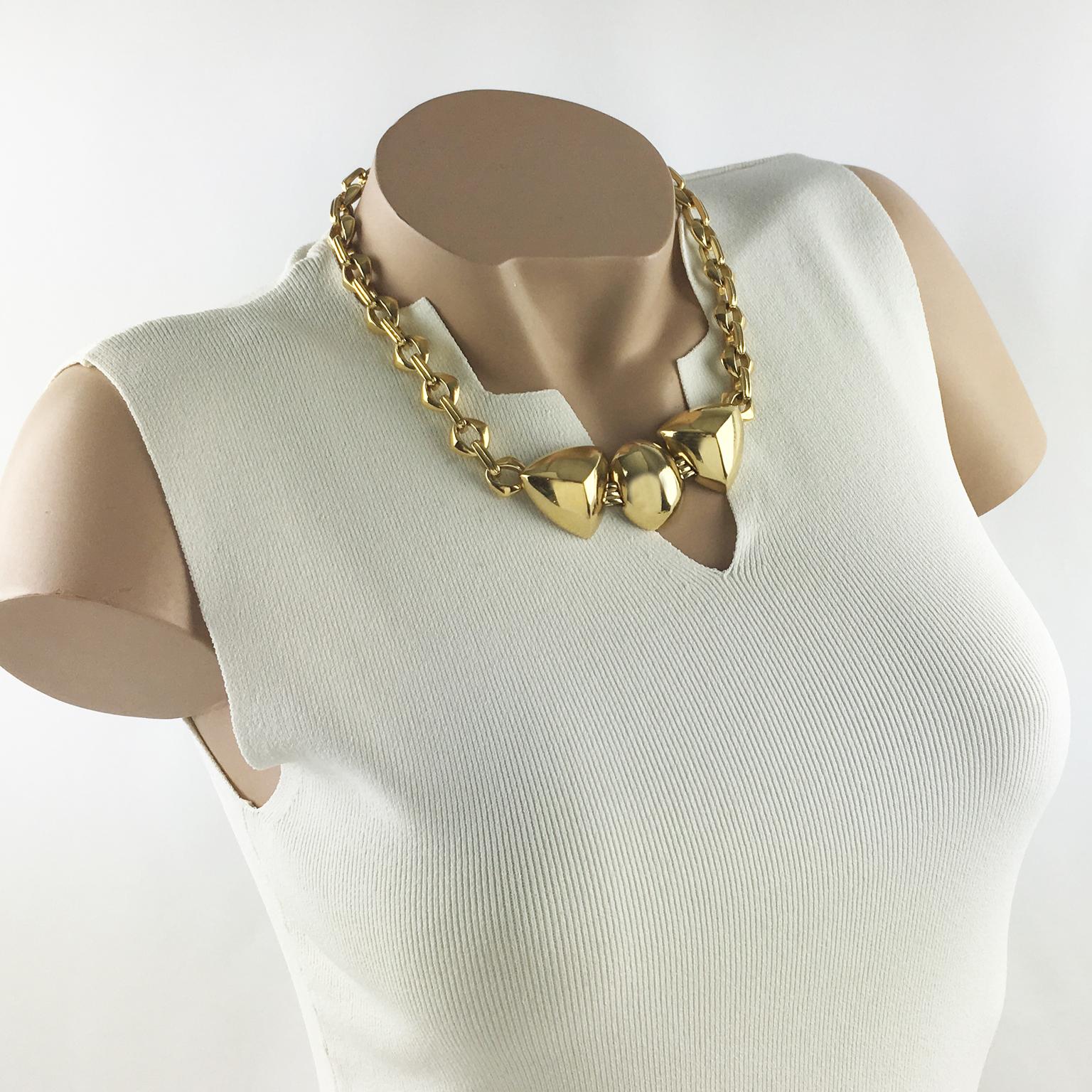 Questa affascinante collana girocollo firmata Yves Saint Laurent Paris presenta un'importante catena lavorata a maglie in metallo dorato con un medaglione geometrico frontale. Il girocollo ha una chiusura con gancio a 