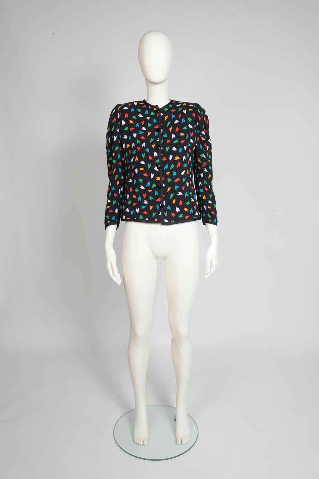 At Julia's Dressing, we do adore Saint Laurent and his cheerful prints ! Designed in a slim silhouette from silk crepe, this late 70's shirt-jacket features a colorful abstract heart pattern. Black ribbed passementerie braid is to be found along the