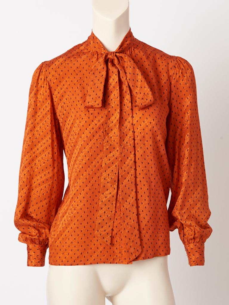 Yves Saint Laurent, Rive Gauche, rust/orange tone, silk jacquard printed, Lavalière, long sleeve blouse,
C. late 70's.