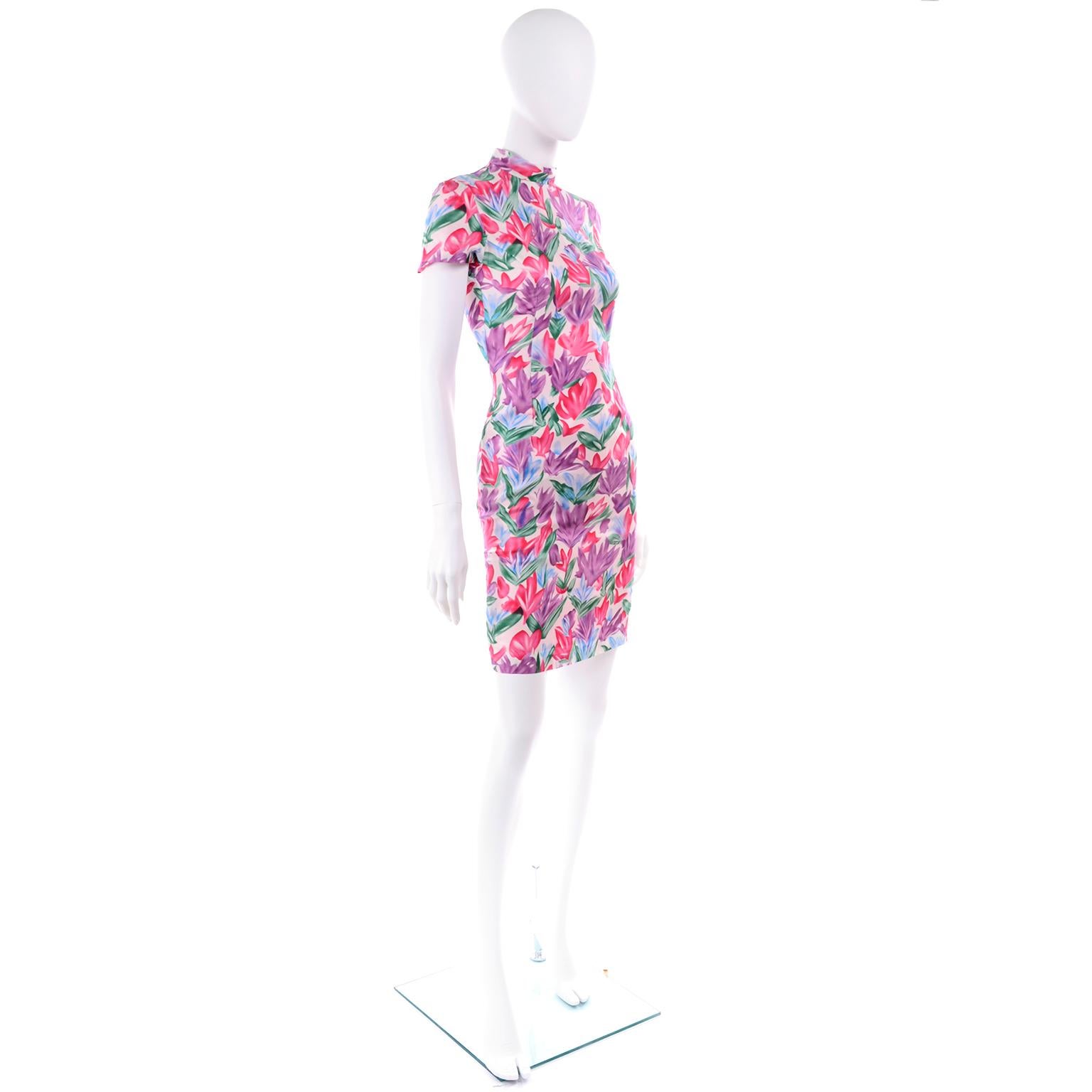 This is a pretty silk dress designed by Yves Saint Laurent, in a magenta pink, purple, blue and green floral print that resembles abstract tulips.  The dress is fully lined and closes with a kdd seamless zipper and a hook and eye.  The sheath style