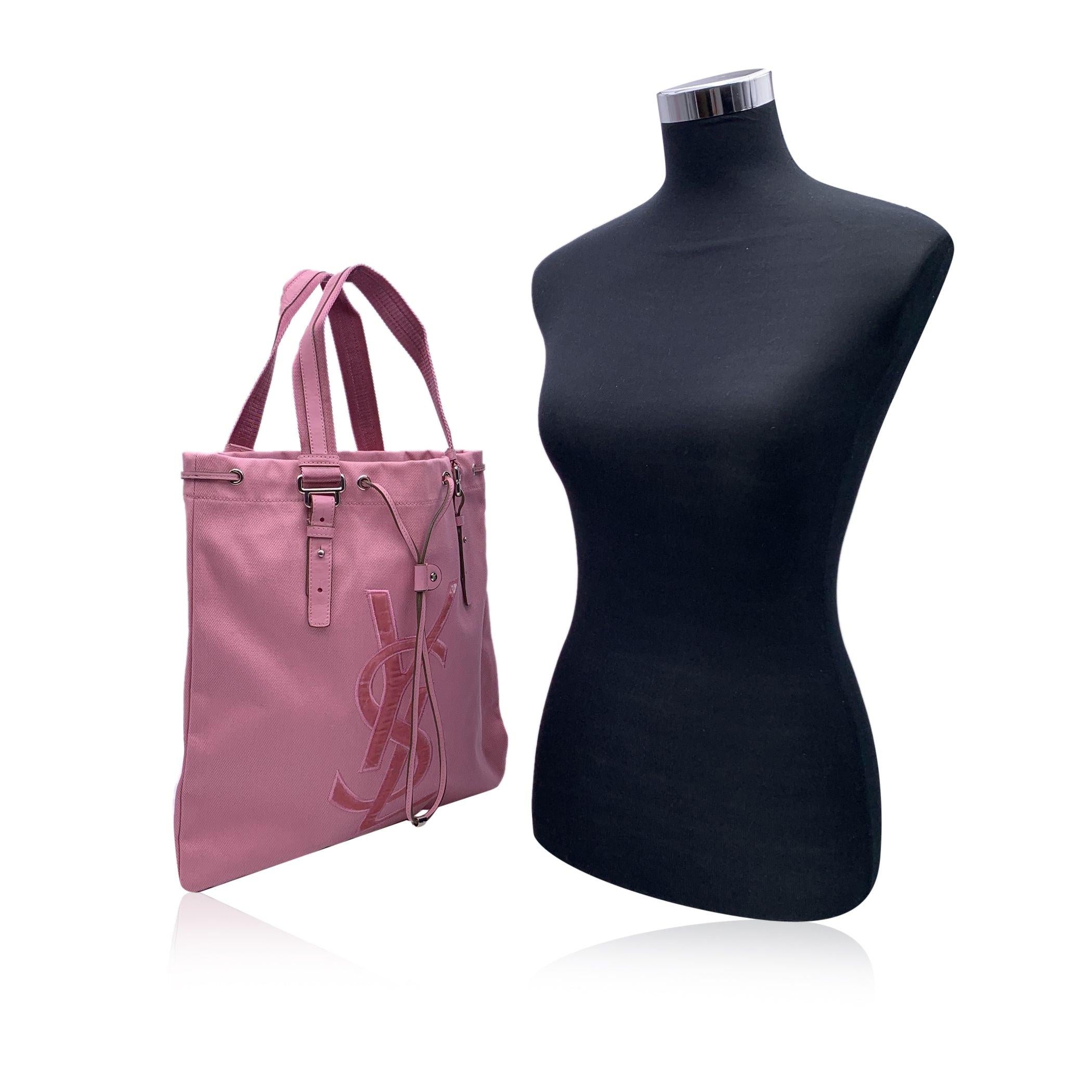 YVES SAINT LAURENT Pink canvas 'Kahala Sac' tote bag, with velvet YSL logo on the front. Drawstring closure on top. Double canvas and leather handles. Satin lining. 1 side zip pocket inside. 'YVES SAINT LAURENT Rive Gauche' tag inside ('made in