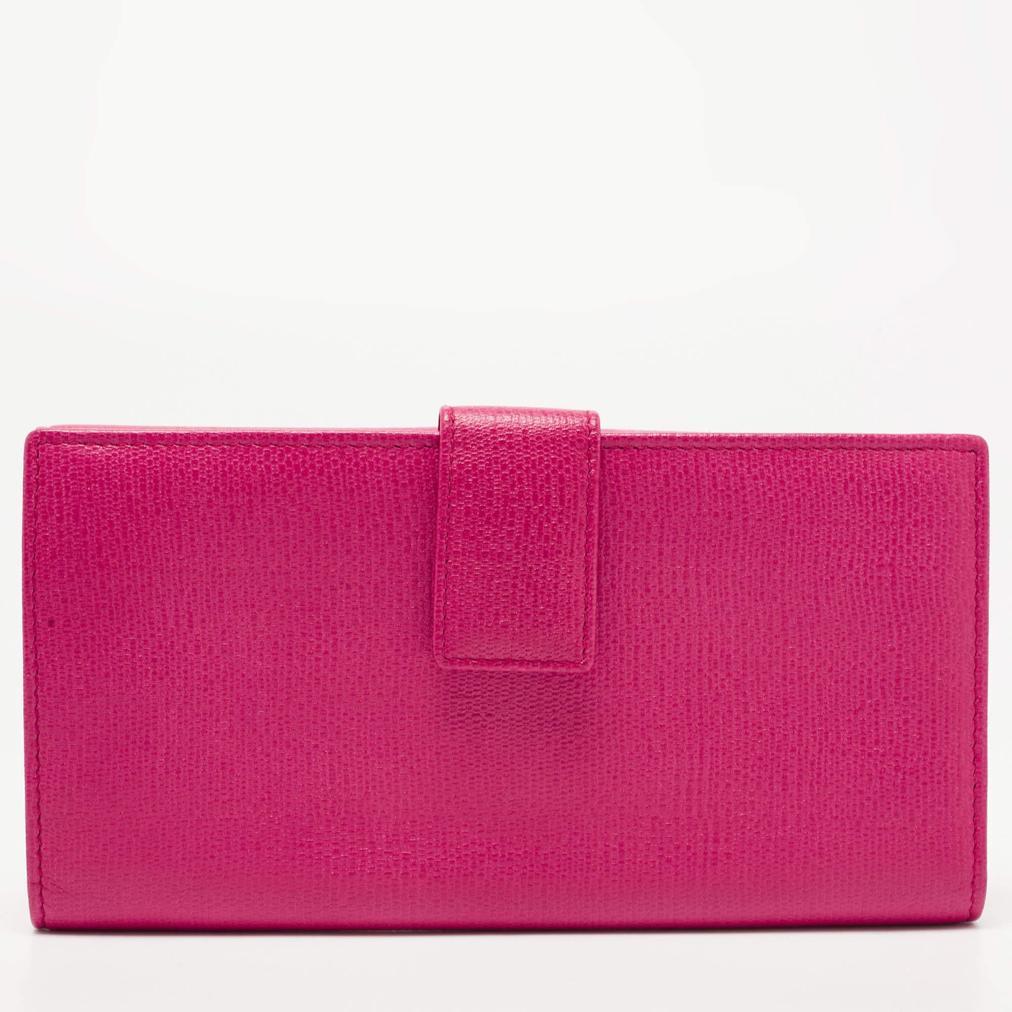Crafted from leather, this luxurious Saint Laurent Paris wallet is a beauty not to be missed! The shiny pink color exterior features a front flap with the branded charm and a snap closure. It opens up to a fabric-lined interior with multiple slots.

