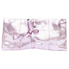Yves Saint Laurent è una pochette avvolgente in pelle rosa metallizzata squamata
