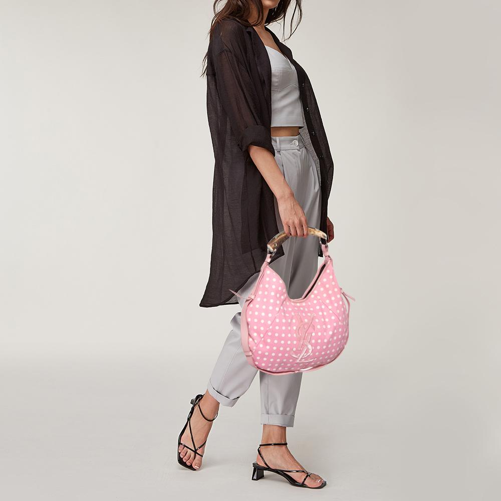 You will love to have this Saint Laurent Mombasa hobo. Crafted from pink-white polka dot printed fabric and held by a horn handle, it is a beauty. The interior is lined with satin and sized to house your essentials with ease.

