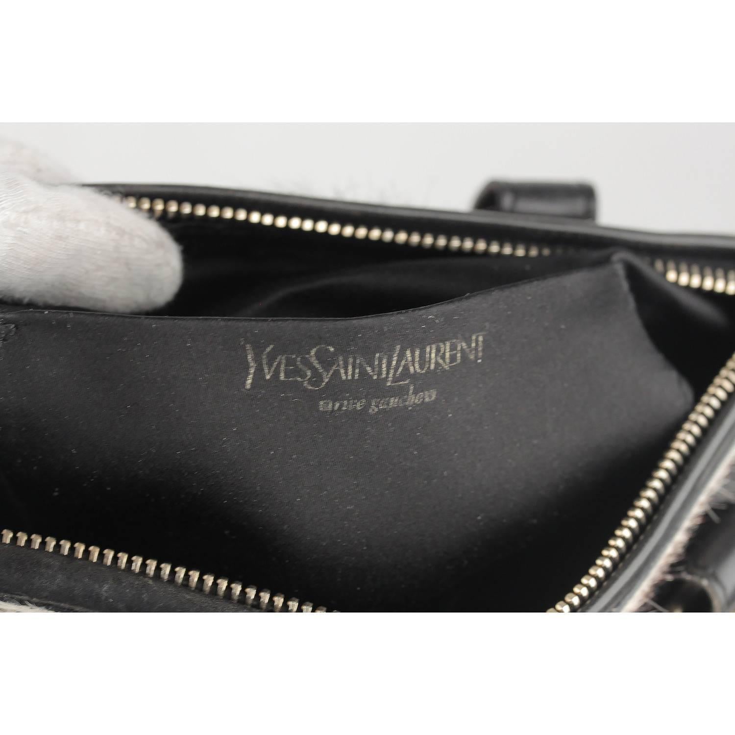 - Yves Saint Laurent Black leather shoulder bag with pony hair panels
- Features  gold metal hardware on the front and on the back
- Double flat leather handles
- Upper zipper closure
- Black satin lining
- 1 side open pocket inside
- Four