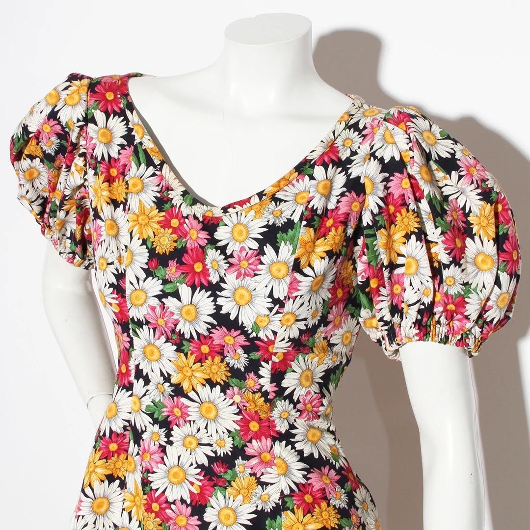 Yves Saint Laurent Mini Dress 
Spring / Summer 1992 
Made in France 
Pink, green,black, white, yellow and green daisy print 
Pouf sleeves  
Elastic at cuff of sleeve for fit
Open neckline 
100% Cotton 
Interior lined in 55% Acetate 45% Rayon green
