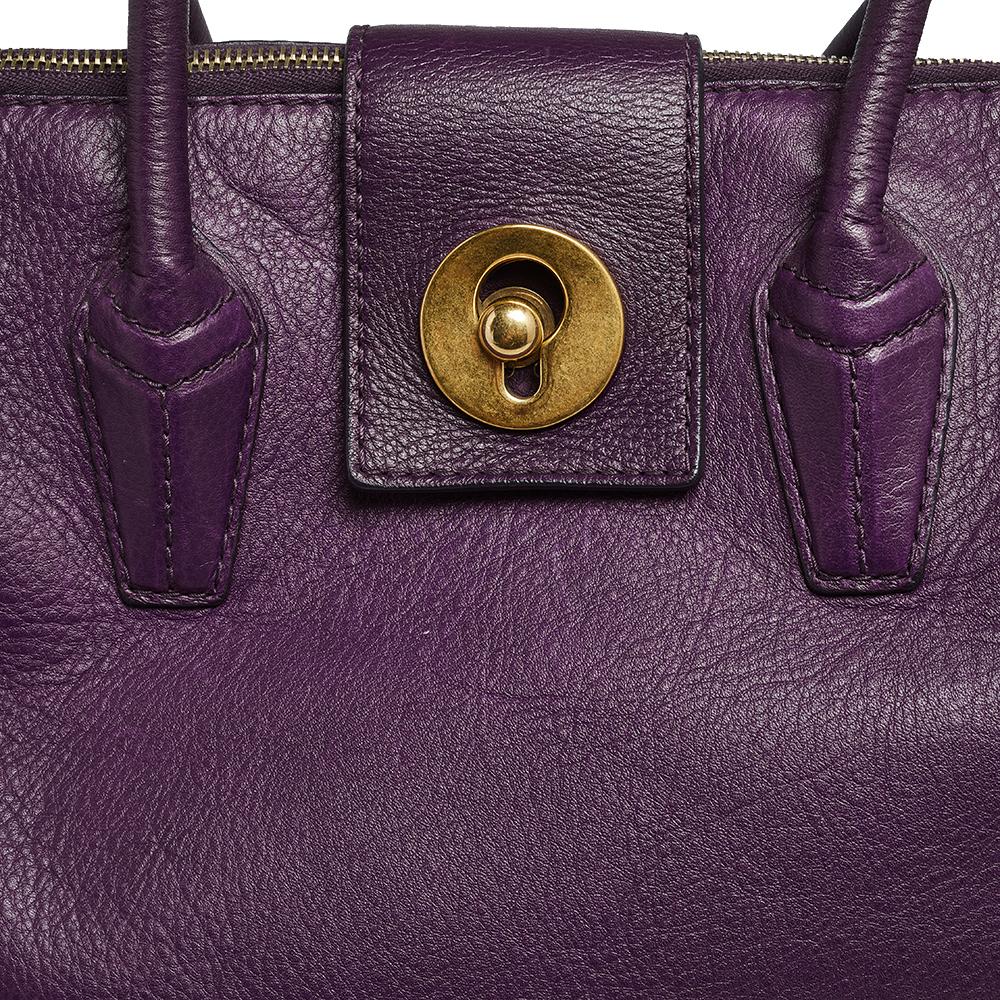 This Yves Saint Laurent Muse Two bag is perfect for everyday use. It has an exterior meticulously crafted from purple leather. This bag has top handles and a gold-tone front lock. The zip closure opens to a roomy canvas-lined interior.

