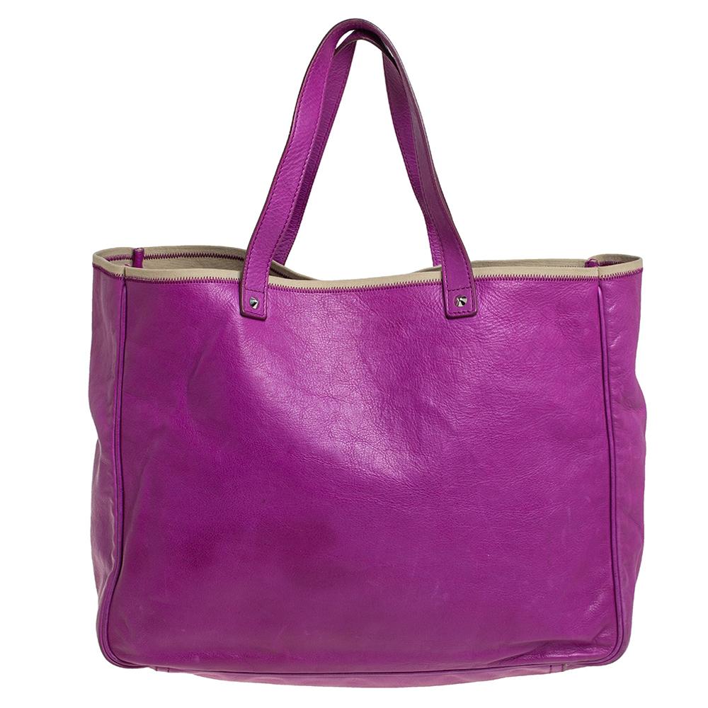 We all need one tote that will not only help assist our style but also be versatile enough for all our outings. Here's one from Yves Saint Laurent. It comes finely crafted from leather in a beautiful purple shade. The dual handles and a spacious