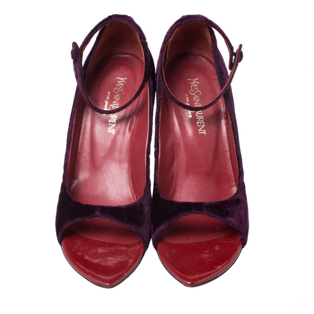 Make a fashion statement with these wedges from Yves Saint Laurent. The classic wide peep-toe design opens to deep red leather insoles, while the velvet body is highlighted in a stunning shade of purple. Wear these shoes with confidence thanks to