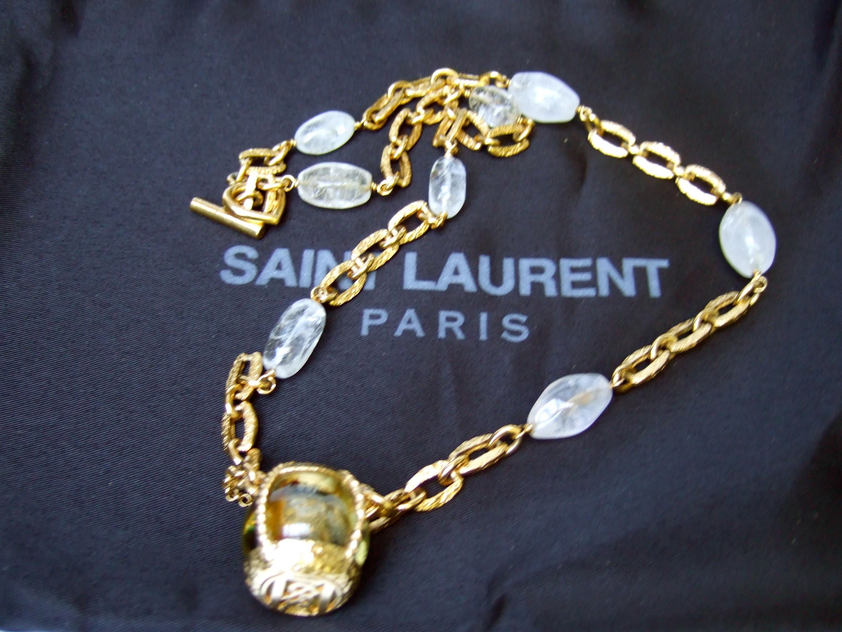 Yves Saint Laurent Rare crystal rock gilt metal chain necklace designed by Robert Goossens 
The chunky hammered link crystal rock chain necklace is designed with a dangling pendant glass orb 
encased in a gilt metal fob that originally contained