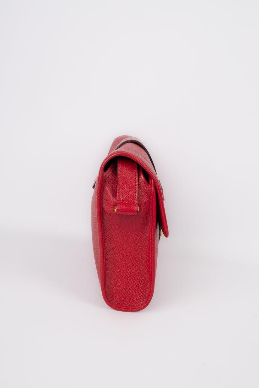 Yves Saint Laurent - (Made in France) rote Ledertasche mit goldenen Metallelementen. Zu erwähnen ist, dass ein Teil des goldenen Materials auf dem Metall fehlt.

Zusätzliche Informationen:
Zustand: Sehr guter Zustand
Abmessungen: Höhe: 17 cm -