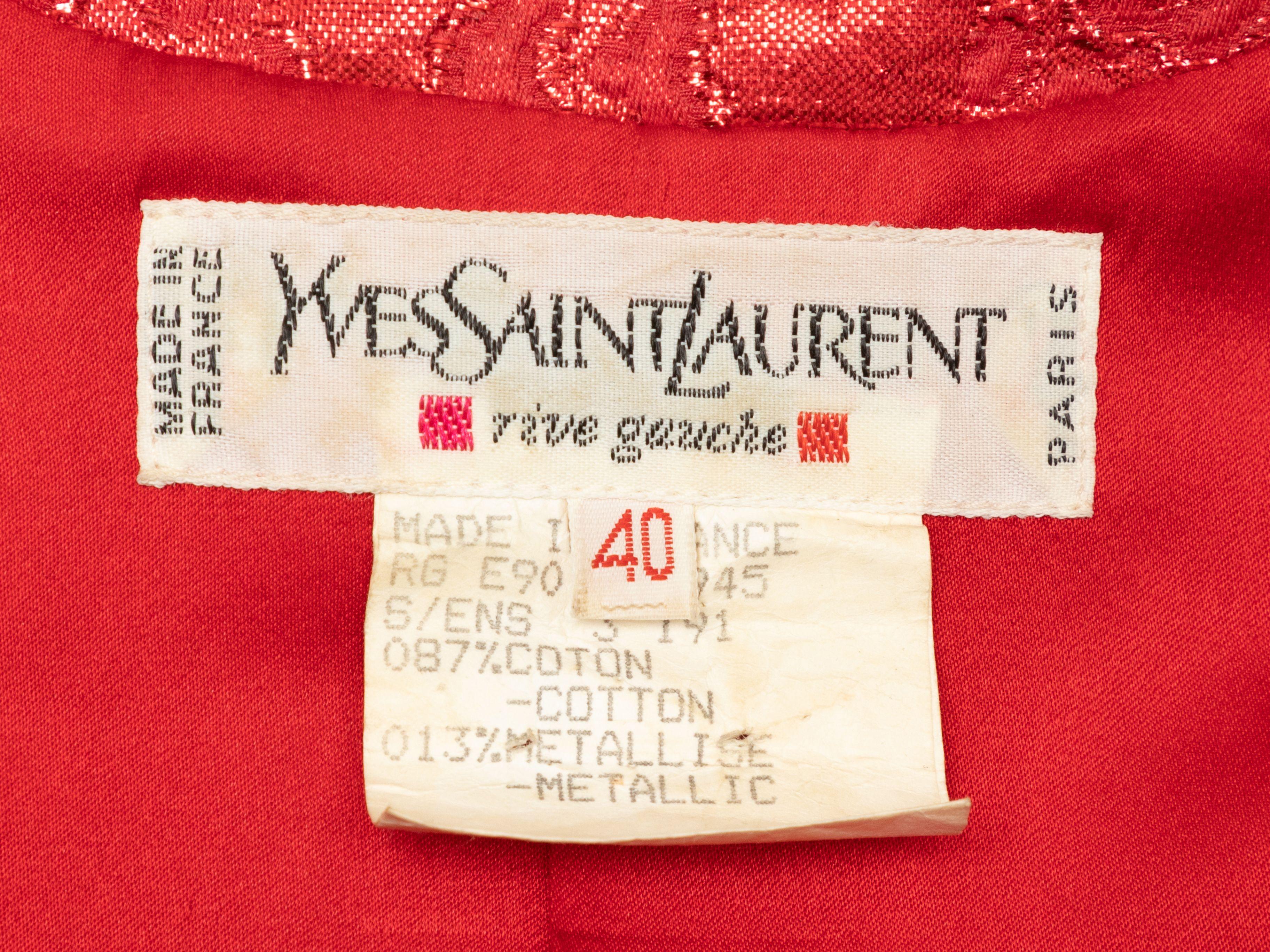 Product Details: Vintage red metallic jacquard collarless jacket by Yves Saint Laurent. Crew neckline. Dual flap pockets at hips. Oversized resin cabochon button closures at front. Designer size 40. 32