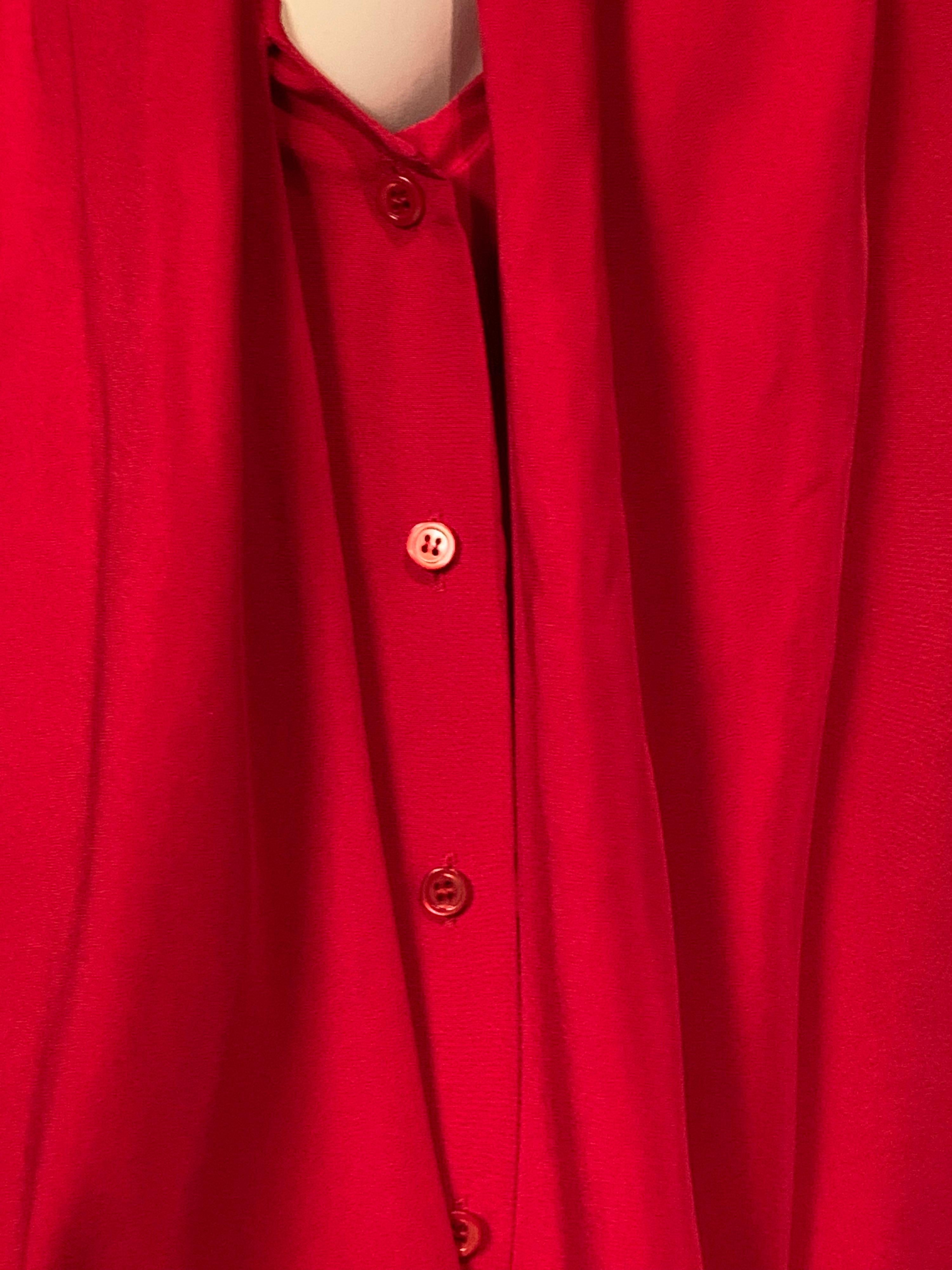 This cheerful red blouse from YSL Rive Gauche is made from a beautiful silk faille.  The blouse has a low neckline with an attached scarf, a button front and two button cuffs.  It is marked a size 40 and it is in excellent condition.
Measurements; 