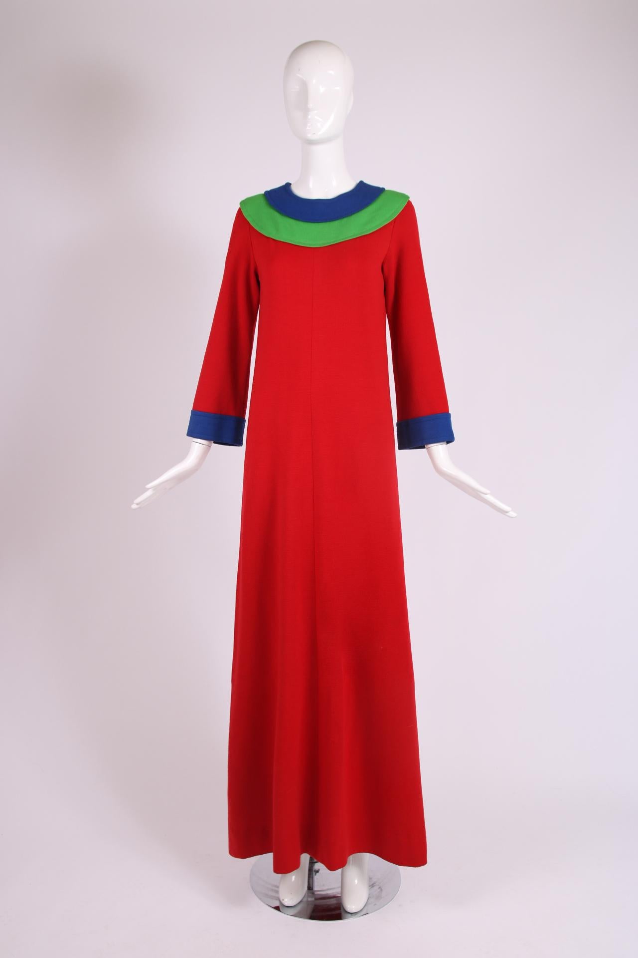 Iconique robe longue en laine rouge Yves Saint Laurent avec bordure en laine bleue et verte. La robe est vendue à un prix très réduit car elle présente plusieurs problèmes d'état - la doublure intérieure rouge en soie a quelques déchirures et trous,