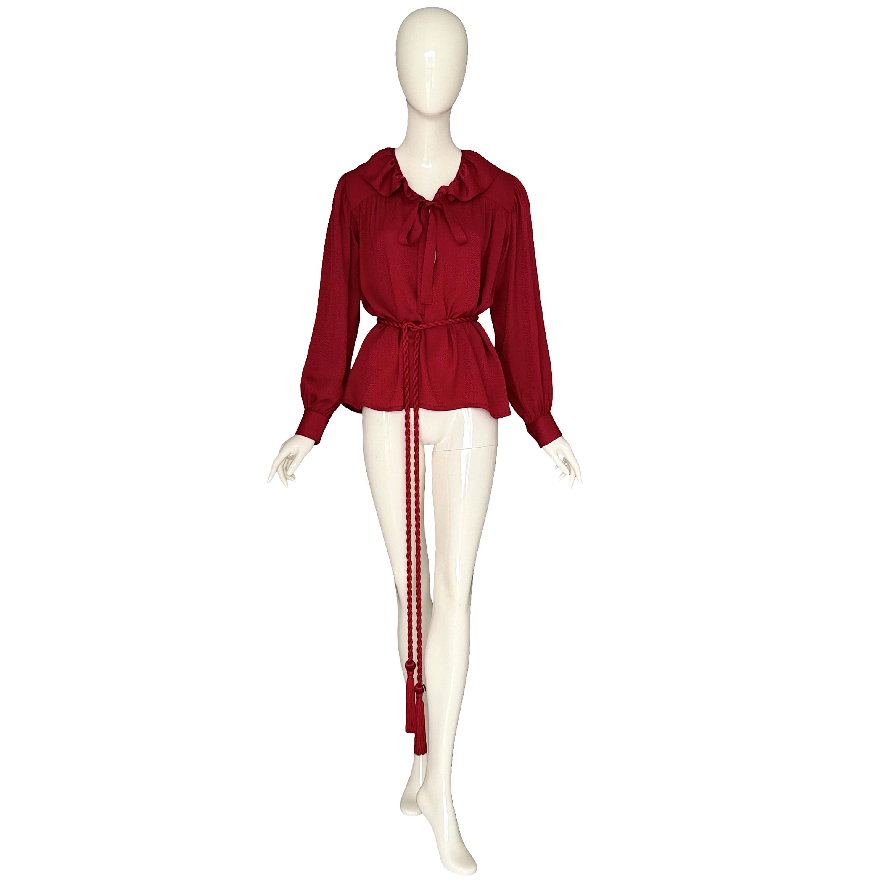 Diese Vintage Yves Saint Laurent Rive Gauche Bluse aus den späten 1970er bis frühen 1980er Jahren ist aus weicher roter Seide gefertigt. Es hat einen gerüschten Ausschnitt mit Schleife, lange Ärmel mit Knopfmanschetten und einen fließenden,