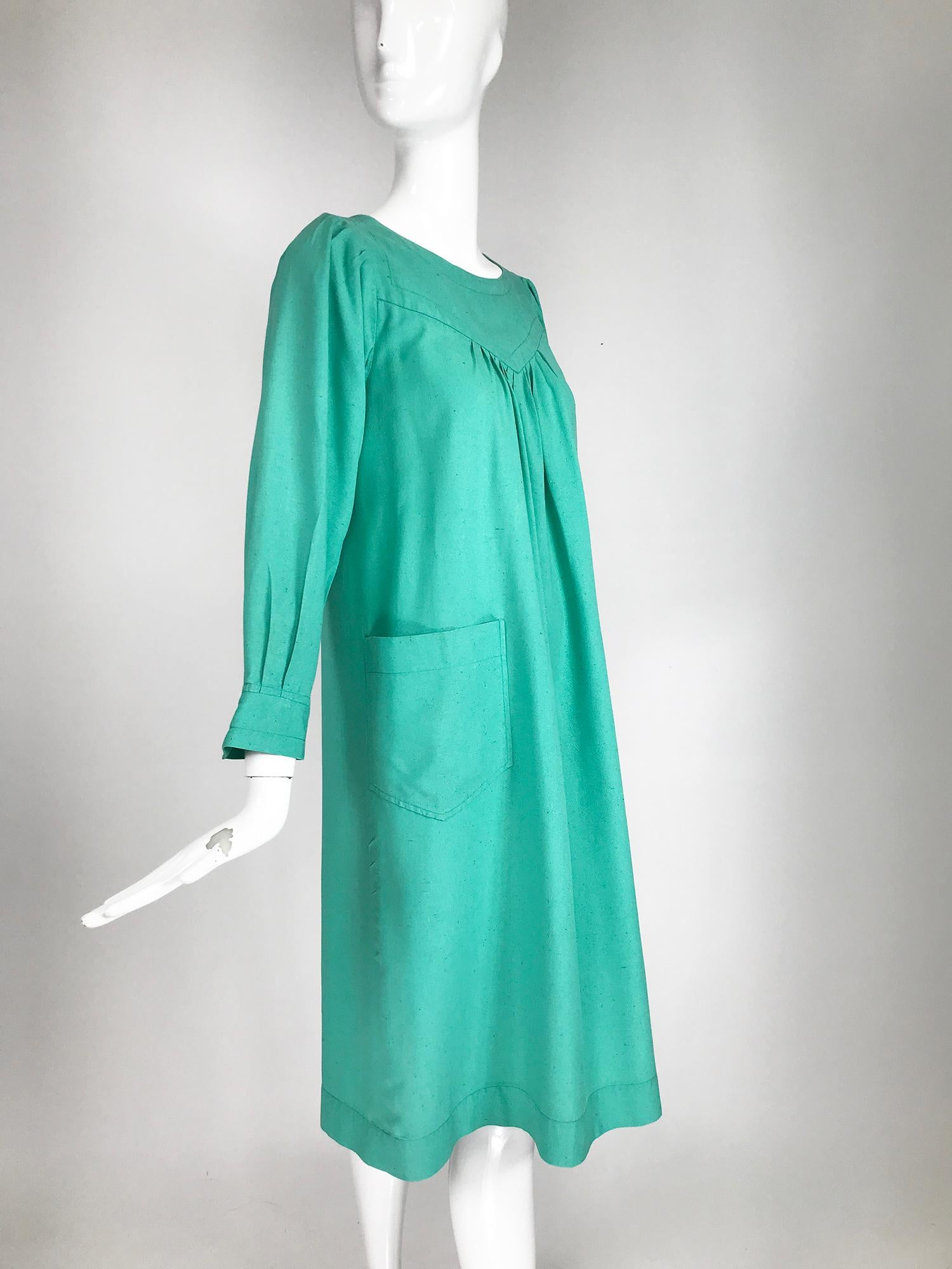 Yves Saint Laurent Rive Gauche aqua slub silk smock dress from the 1970s. Pull on dress has round neckline with a yoke front and back, the dress is gathered above the bust front and Back. Long full sleeves have wide cuff that is open and can be