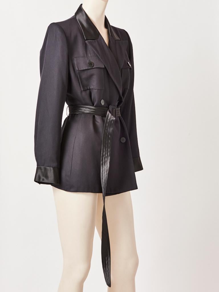 Yves Saint Laurent, Rive Gauche, black, silk, belted, double breasted, Safari/Tuxedo jacket, having wide lapels, breast pockets and a long satin belt. C. 1980's.