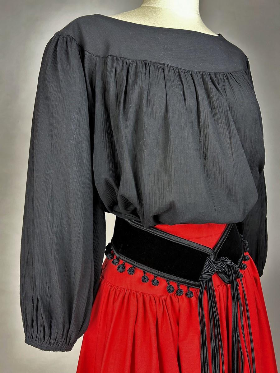 Spring Summer 1977

France

Blouse and skirt set from the Ballets Russes Collection by Yves Saint Laurent Rive Gauche dating from 1977. Red and black outfit with pompom fringes and Hispanic accents. A Russian type Blouse in black cotton with crepe