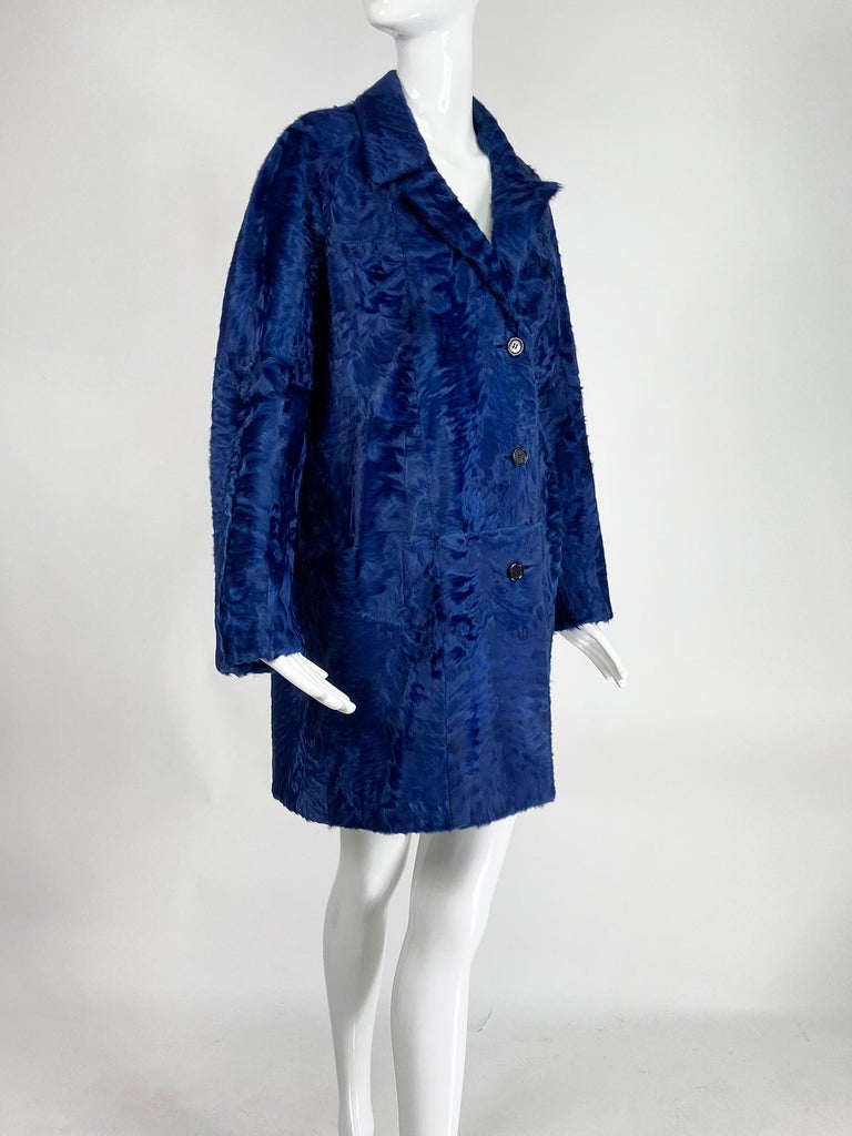 Yves Saint Laurent Rive Gauche YSL sheared lamb coat in blue from the early 2000's. Single breasted, raglan sleeve, coat with notched lapels & v neckline. Hip front pockets. Long sleeves. Center hem back vent. Knee length coat is lined in blue