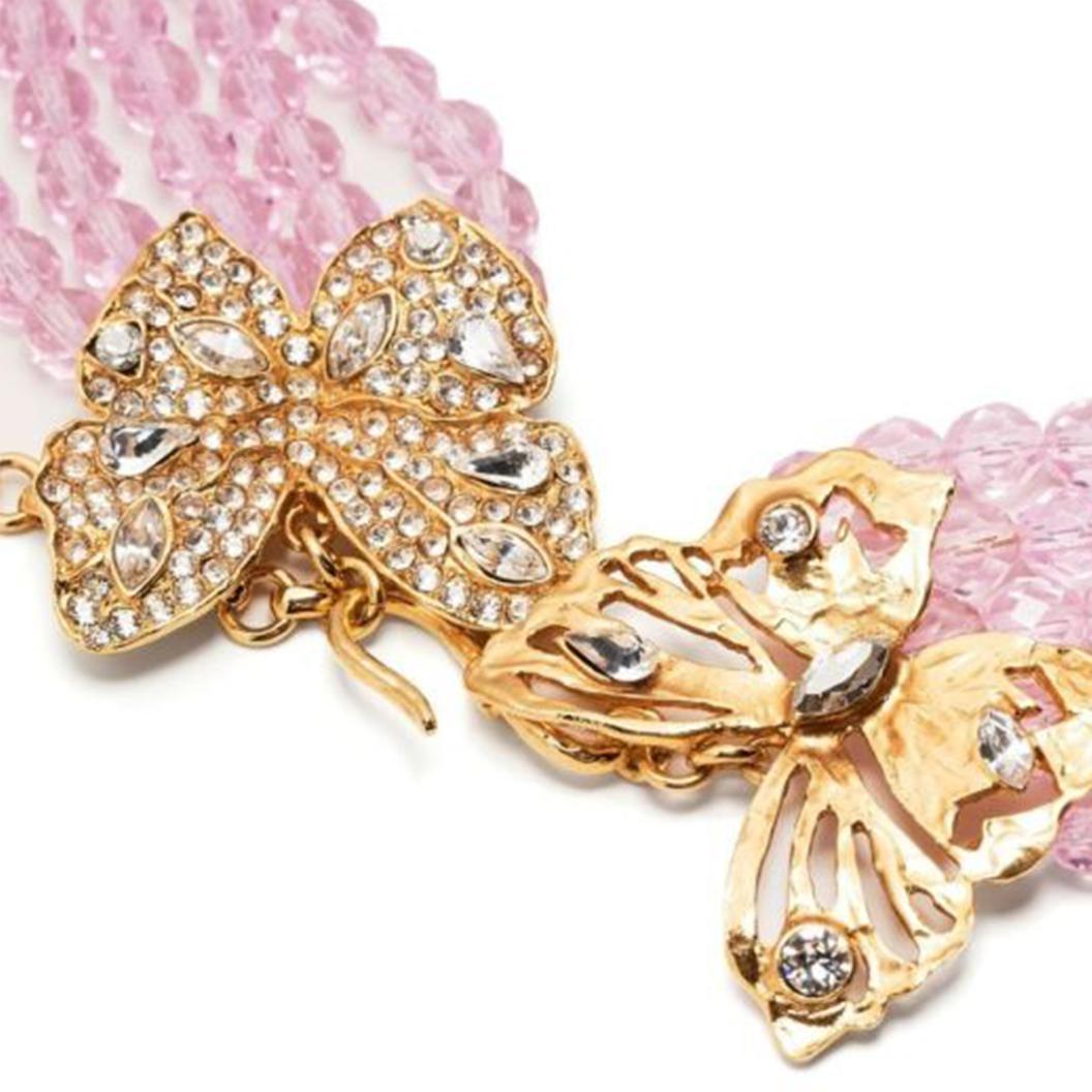 This stunning pre-owned necklace by Yves Saint Laurent features five rows of pink crystal beads. Hanging around your neck, the detailing will rest perfectly across your chest for an elegant look. Featuring two butterfly motifs in gold metal that are