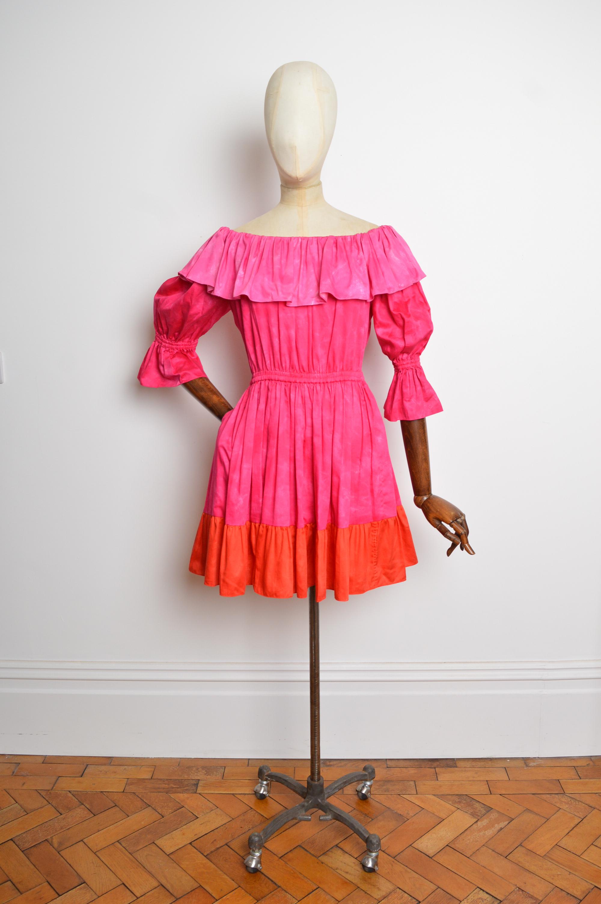 Un minivestido YVES SAINT LAURENT divertido y de colores vivos. Circa 1977, con silueta sin hombros, cintura holgadamente elástica, mangas de pulsera 3/4, dobladillo por encima de la rodilla y bolsillos relajados en las caderas. 
FABRICADO EN