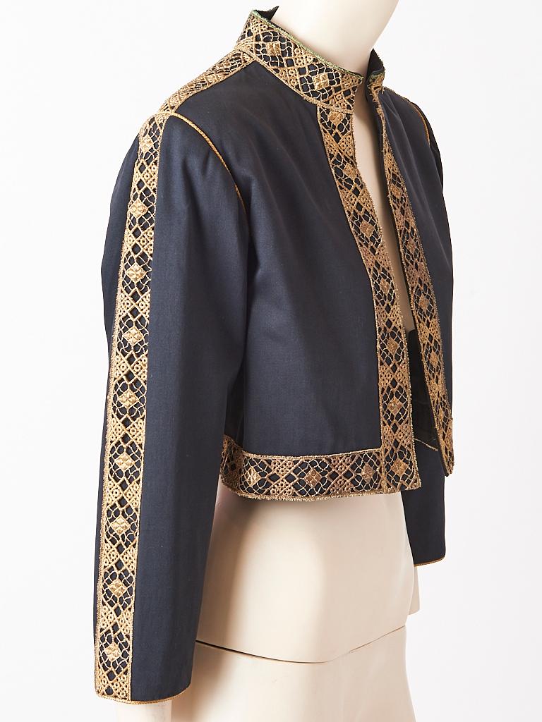 Yves Saint Laurent, Rive Gauche, heavy weight, cotton, cropped jacket, having gold metallic, open work, ribbon lace detail along the mandarin collar, middle sleeve, shoulder, front and hem. There is a fine braided gold cord at the shoulder line. No