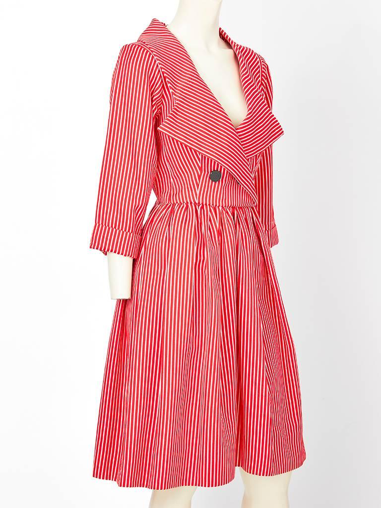 Yves Saint Laurent, Rive Gauche, red and white stripe, double breasted, cotton day dress having an exaggerated notched, lapel, open collar, fitted bodice and gathered skirt.

