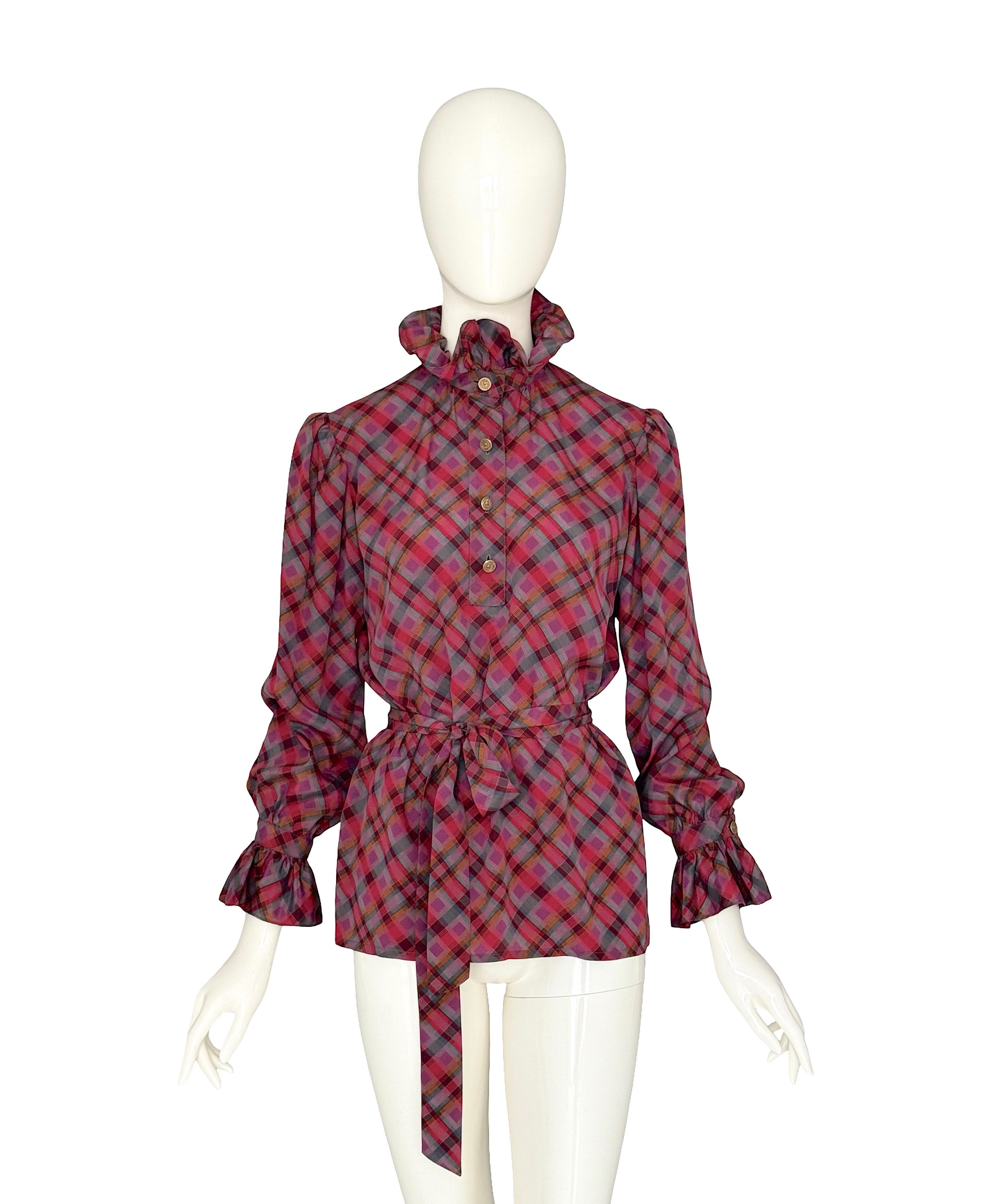 Vintage Yves Saint Laurent Rive Gauche by Mr St Laurent silk set from the Fall/Winter 1979 runway collection. L'ensemble comprend un chemisier et une jupe assortie en 100 % soie écossaise aux riches couleurs.
Le chemisier présente un col montant à