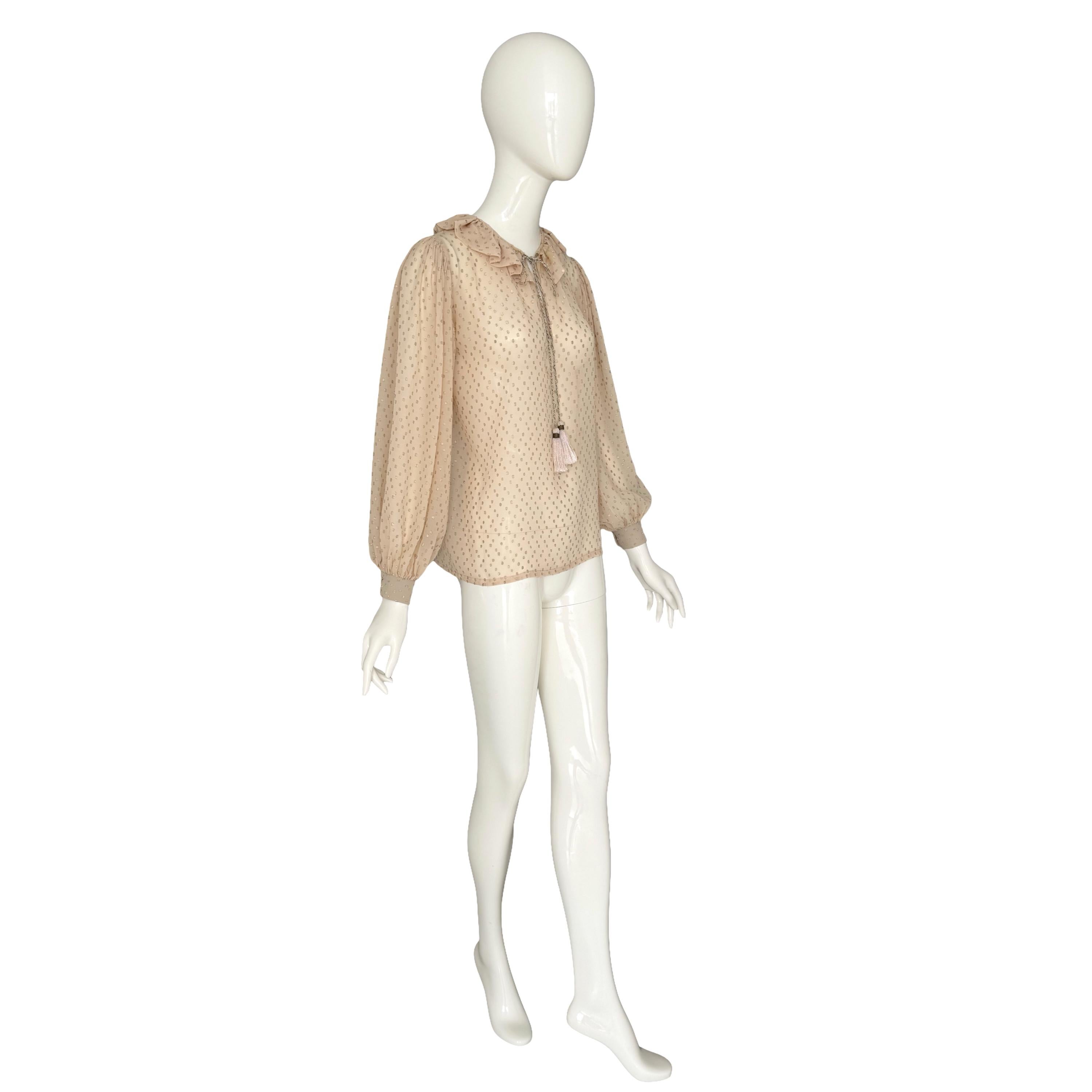 Un'incredibile blusa Yves Saint Laurent rive gauche della collezione Autunno-Inverno 1978, realizzata in un pregiato crêpe di seta cremoso con punti metallici dorati intrecciati. Il taglio è semplicemente delizioso, con un colletto arruffato e