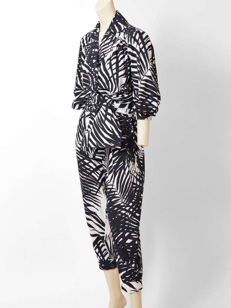 Yves Saint Laurent, rive Gauche, black and white, cotton, graphic, palm leaf pattern blouse and jogger pant ensemble. Blouse has an oversize, notched collar with a single black button closure  and a wide sash. Pant is a jogger shape that tapers at