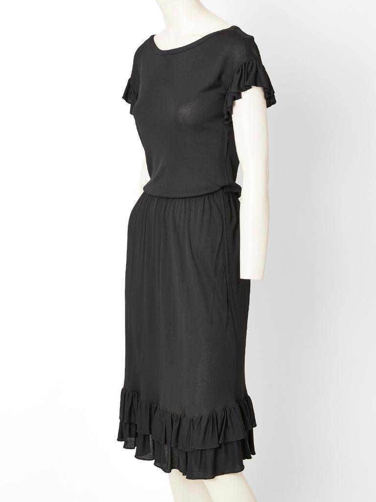 Yves Saint Laurent,  Rive Gauche, black jersey, day dress having ruffled accents at the hem and sleeve edging. Dress is gathered at the waist with a scoop neckline.
