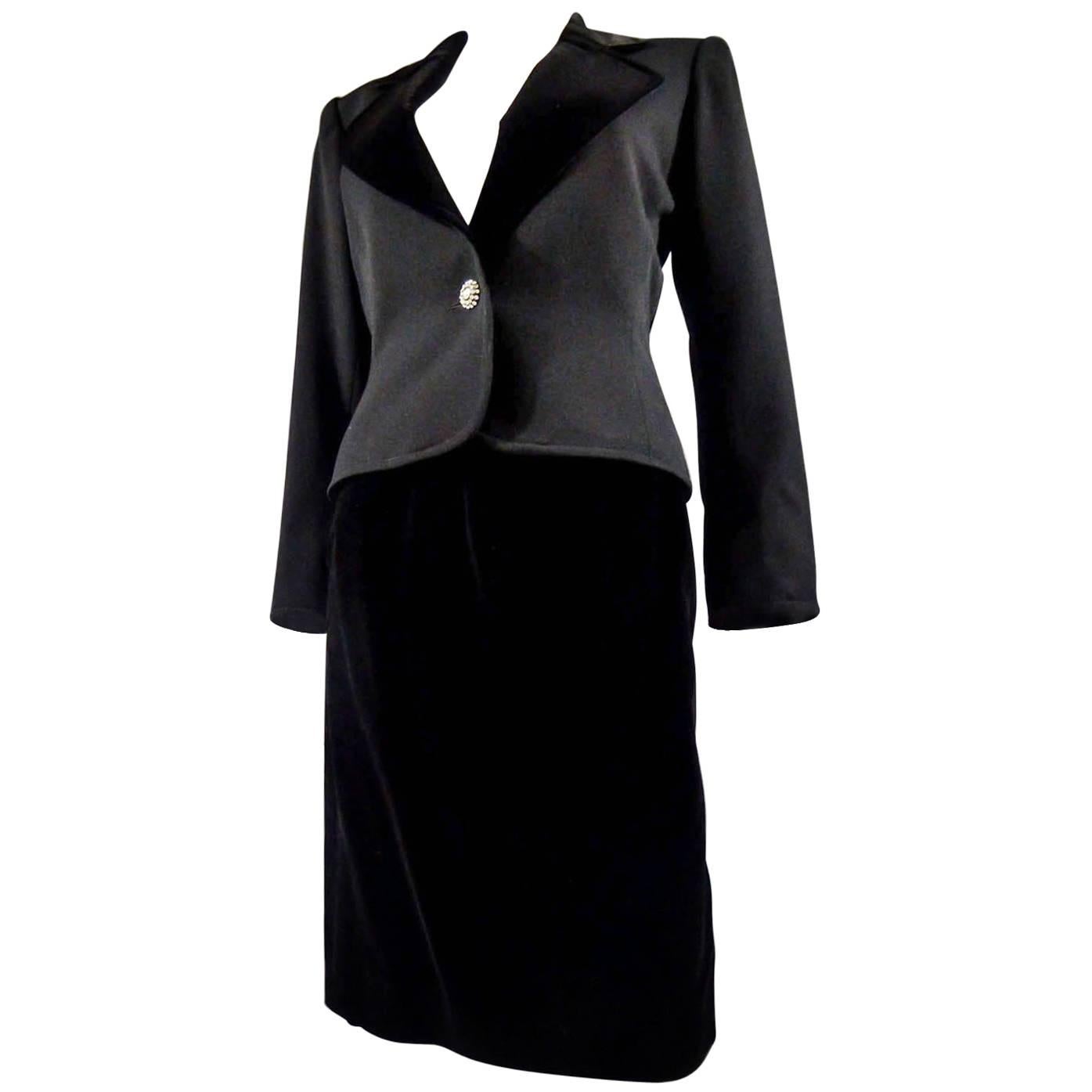 Alrededor de 1980-85. Francia
Falda de esmoquin Yves Saint Laurent Rive Gauche con botones joya. Falda y solapa de la chaqueta de terciopelo de seda negro. Falda recta con bolsillos y cremallera lateral. Chaqueta de esmoquin, acampanada en las