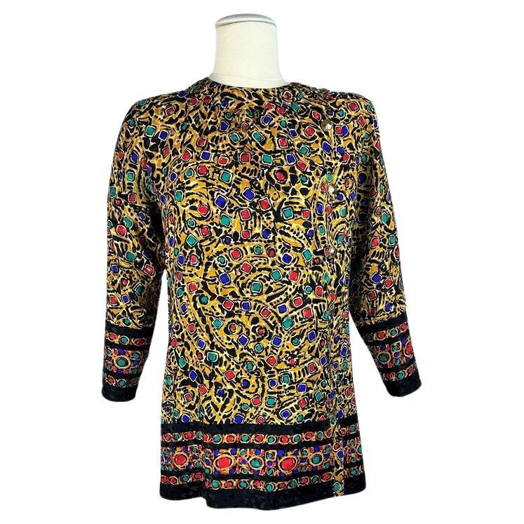 Alrededor de 1980-1985
Francia
Blusa túnica de estilo ruso en damasco de seda con estampado joya de Yves Saint Laurent Rive Gauche de la década de 1980. Corte amplio, fluido, con hombros y mangas largas. Cuello redondo y parte delantera cruzada con