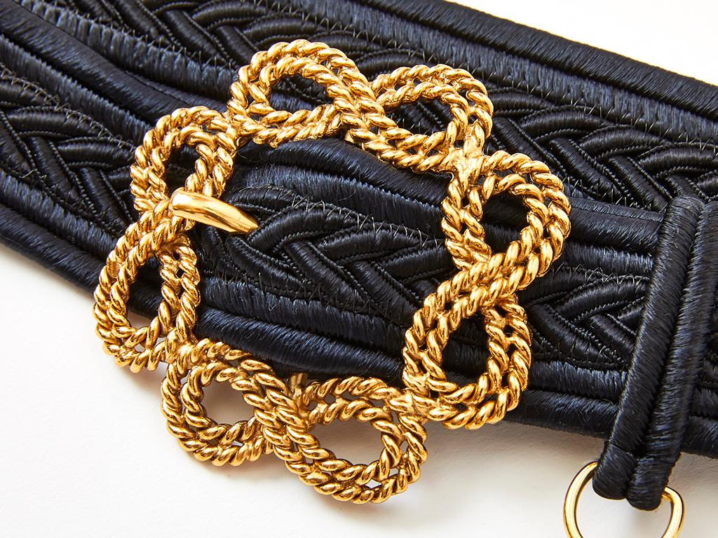 Yves Saint Laurent, black, braided, cord belt, having a gold tone, rounded filigree buckle with a textured heart charm dangling from the belt loop. Charm is signed 