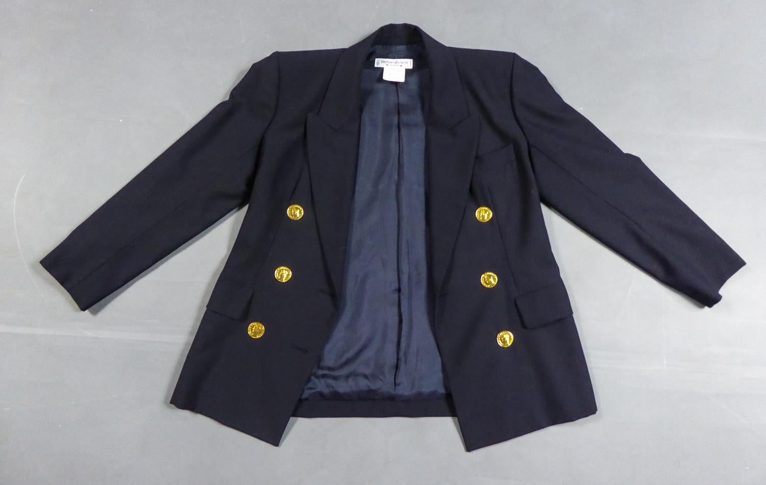 Circa 1990
Francia

Giacca in lana blu navy di Yves Saint Laurent Rive Gauche degli anni '90. Ispirazione ovvia dal guardaroba maschile, il cui taglio aderente evoca l'androginia degli anni '30 e Marlène Dietrich. Ampio colletto con alette a punta e