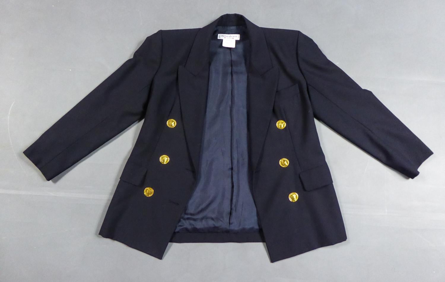 Circa 1990
France

Veste en drap de laine bleu marine Yves Saint Laurent Rive Gauche des années 1990. Inspiration évidente du vestiaire masculin, dont la coupe ajustée évoque l'androgynie des années 30 et Marlène Dietrich. Grand col à rabats pointus