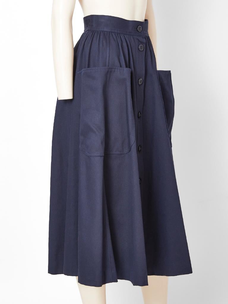 Yves Saint Laurent, Rive Gauche, navy blue cotton, midi skirt, having a gathered waist, center front button closures going down to the hem and large patch side pockets.