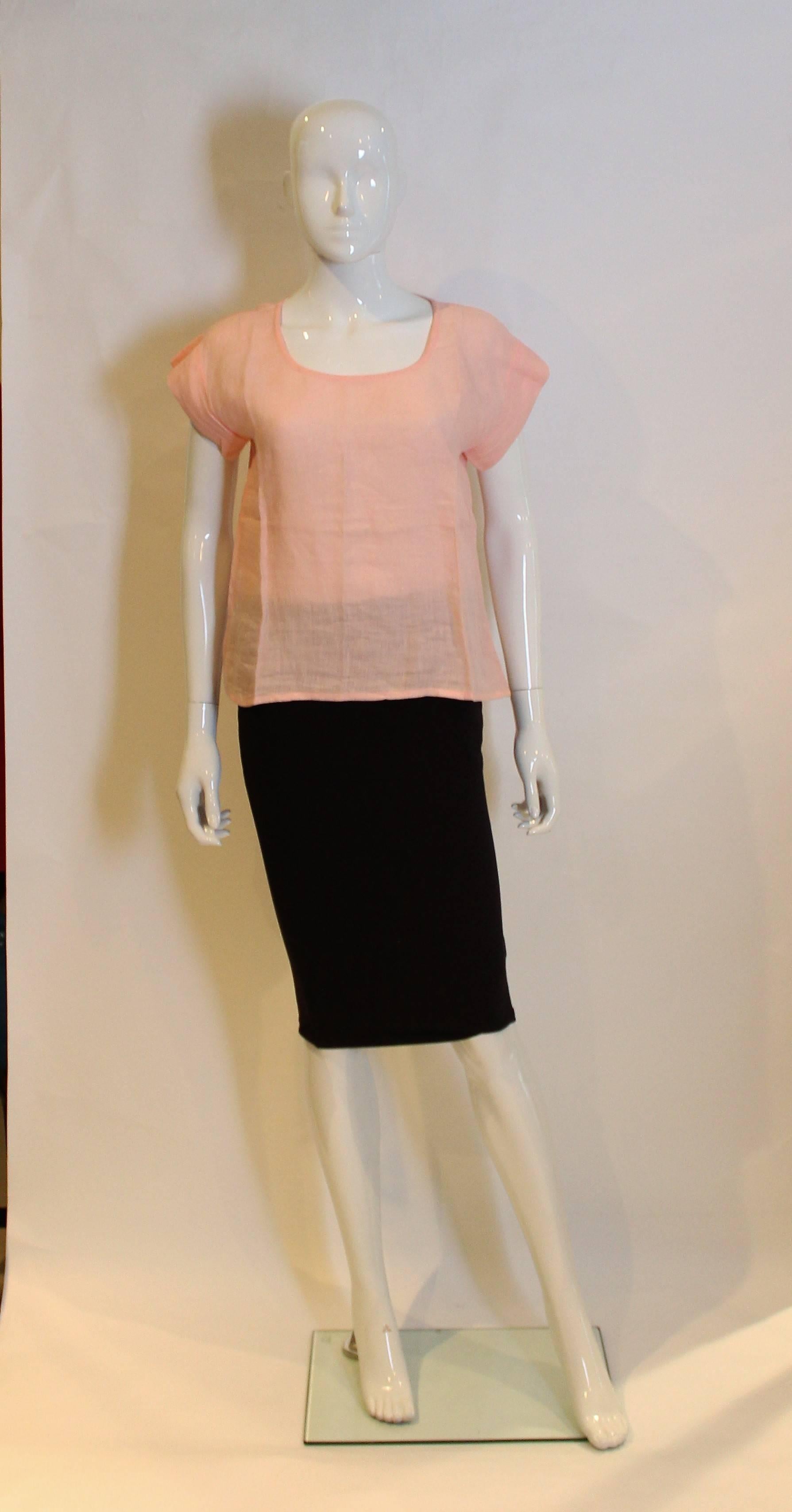 A pretty pink linen top by Yves Saint Laurent Rive Gauche.The top has a deep round neckline, and cap sleeves.