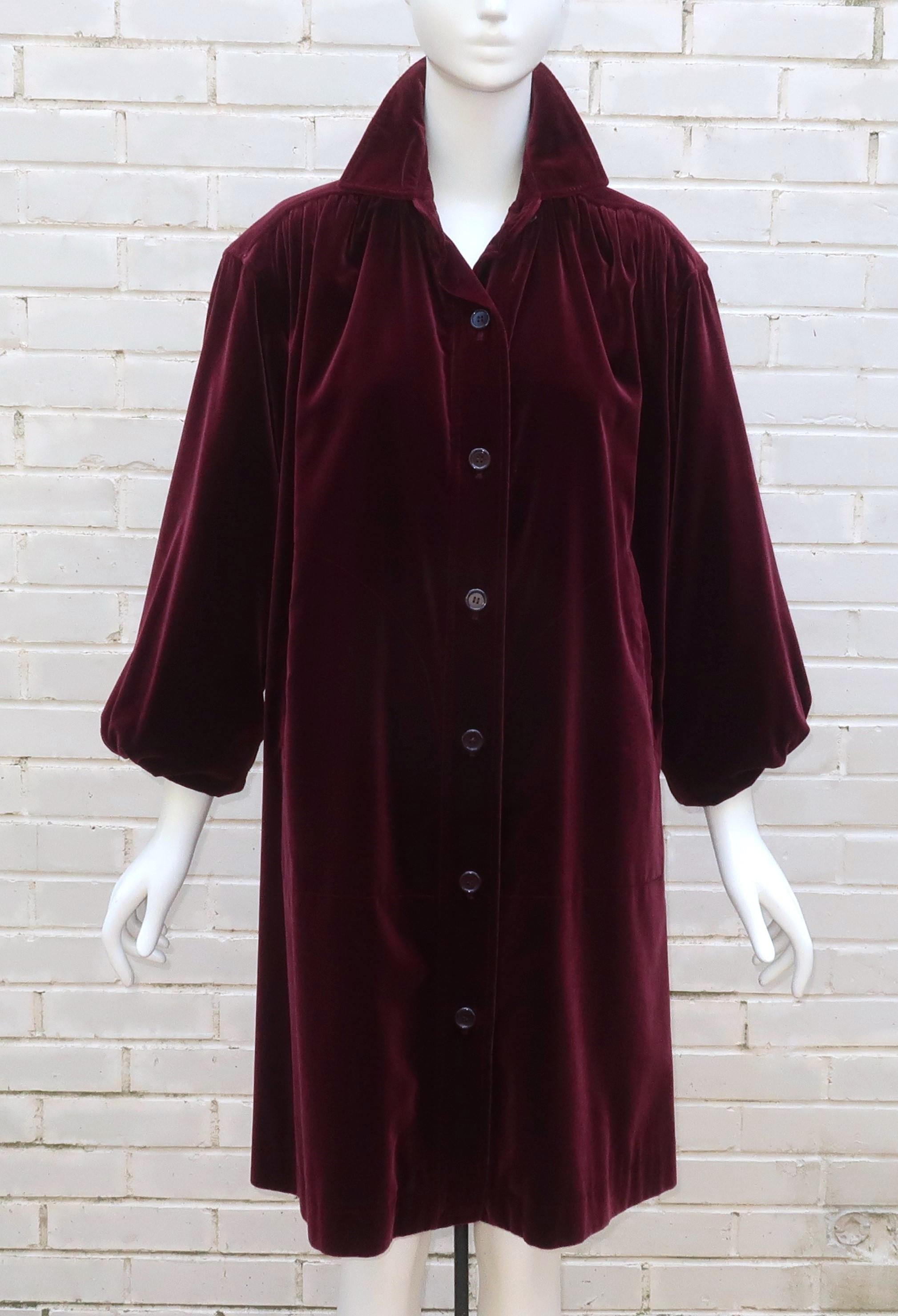 Lush & lovely!  Every sensory perception is stimulated by this gorgeous Yves Saint Laurent coat! The design starts with a rich ruby red heavy weight velvet fabric and moves on to a smock style construction with definition at the shoulders and folds