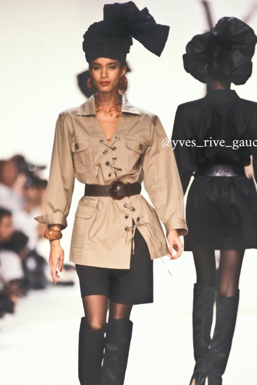 - Collezione primavera/estate 1990 della passerella YSL Rive Gauche di Yves Saint Laurent

- Venduto da Mae Vintage London 

- Giacca sahariana/tunica in gabardina di cotone con grandi bottoni color bronzo e allacciatura asimmetrica sul davanti

-